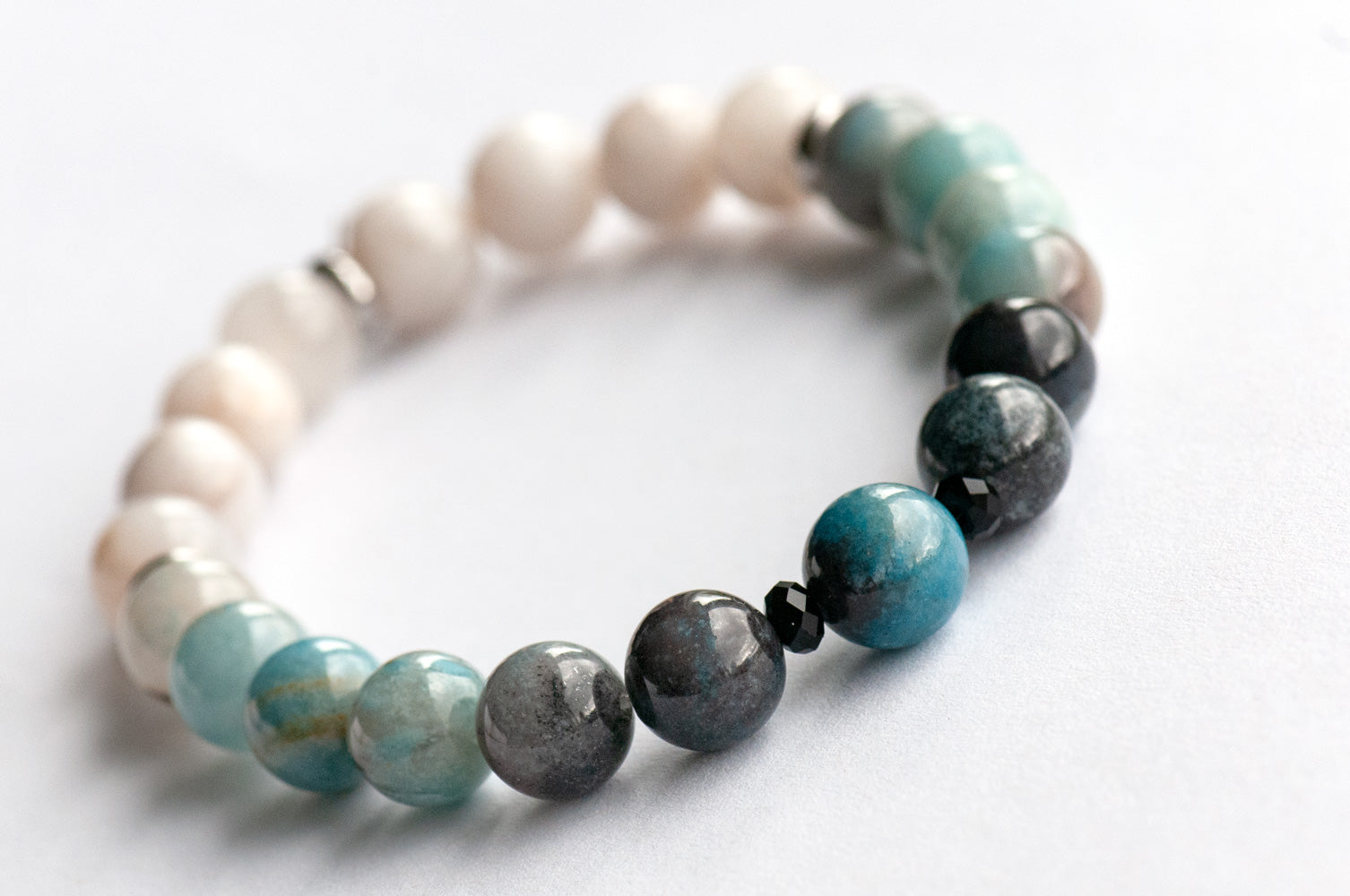 Single strand blue ombre Trolleite bracelet with black onyx accent beads and white Jade, handmade in New Brunswick Canada