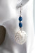 Daring dangle earrings featuring mother-of-pearl carved palm leaves accented with cobalt blue African recycled glass beads and silver-plated accents