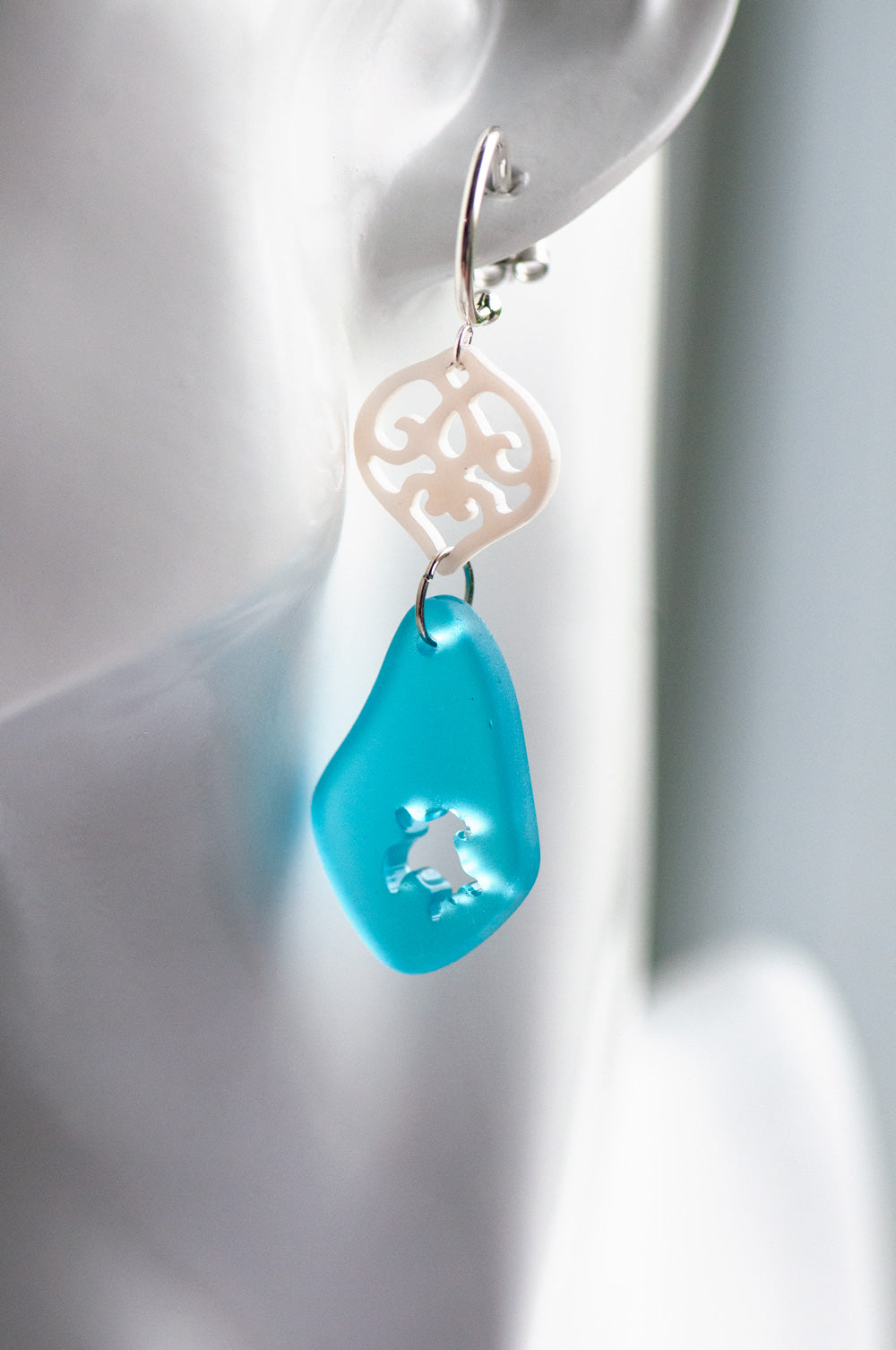 Half hoop studs feature carved freshwater shell hearts, accented with beautiful blue sea glass dangles that have sea turtles intricately carved into them