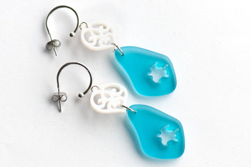 Half hoop studs feature carved freshwater shell hearts, accented with beautiful blue sea glass dangles that have sea turtles intricately carved into them