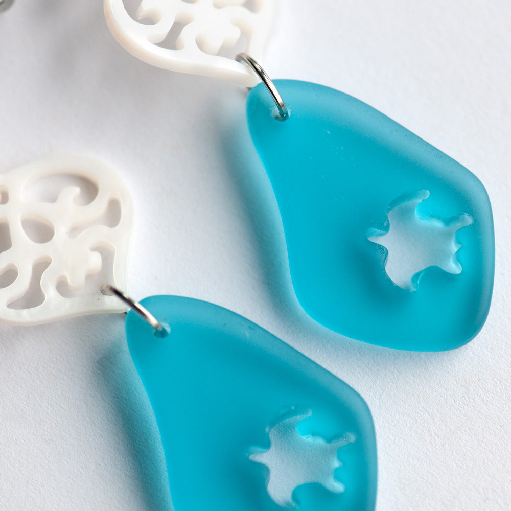 Half hoop studs feature carved freshwater shell hearts, accented with beautiful blue sea glass dangles that have sea turtles intricately carved into them