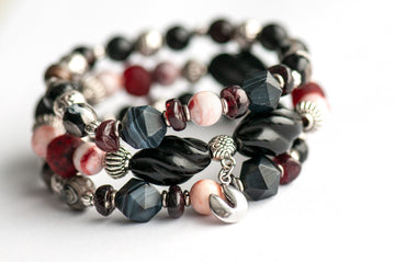 Voyage to Chinatown bracelet featuring a fortune cookie charm, spiral-carved Onyx beads, red and black swirl recycled glass, Cinnabarite beads, with Sardonyx and red garnet chips, complemented by silver-plated Chinese lantern spacers.
