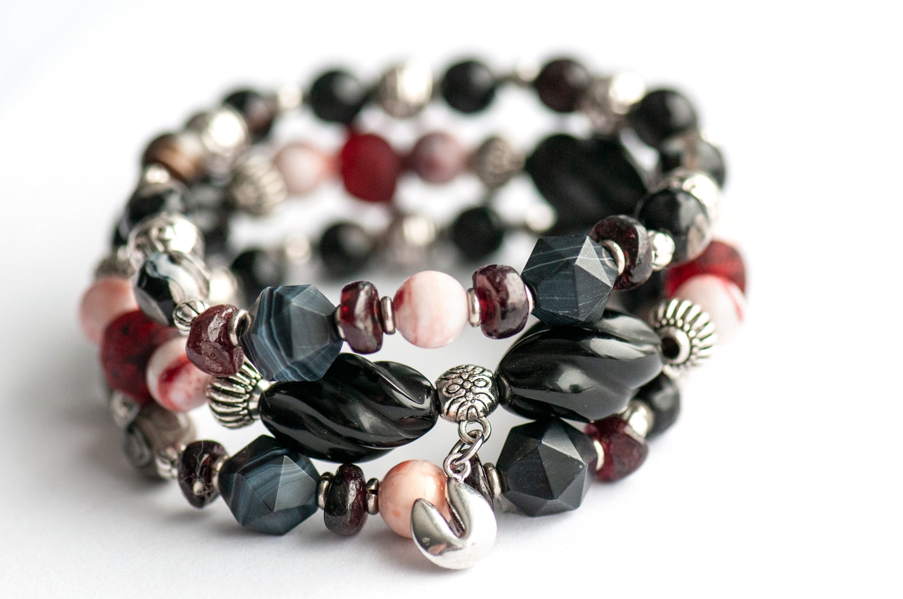 Voyage to Chinatown bracelet featuring a fortune cookie charm, spiral-carved Onyx beads, red and black swirl recycled glass, Cinnabarite beads, with Sardonyx and red garnet chips, complemented by silver-plated Chinese lantern spacers.
