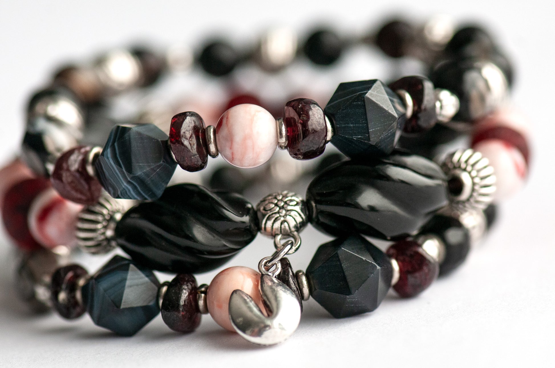 Voyage to Chinatown bracelet featuring a fortune cookie charm, spiral-carved Onyx beads, red and black swirl recycled glass, Cinnabarite beads, with Sardonyx and red garnet chips, complemented by silver-plated Chinese lantern spacers.