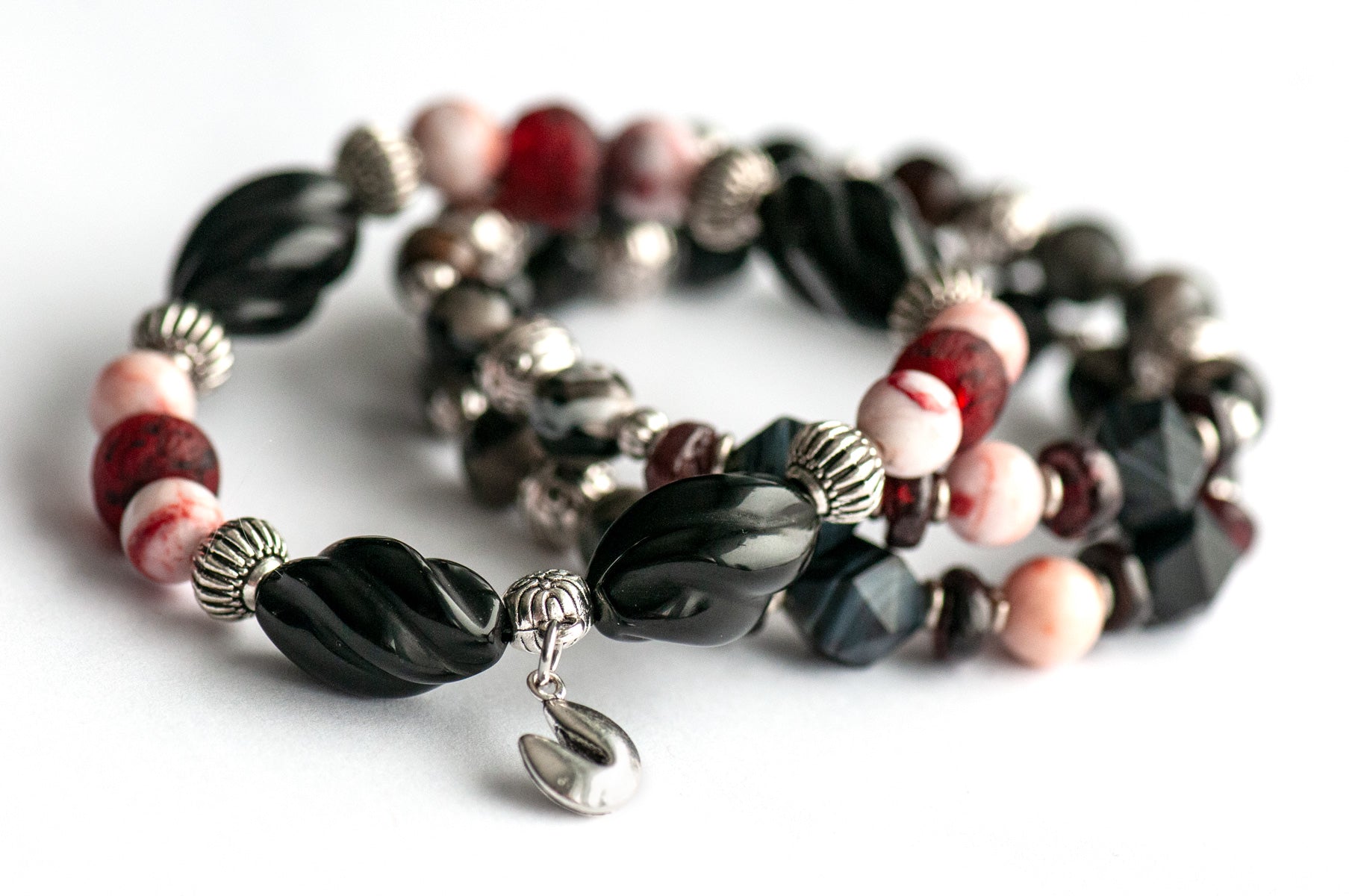 Voyage to Chinatown bracelet featuring a fortune cookie charm, spiral-carved Onyx beads, red and black swirl recycled glass, Cinnabarite beads, with Sardonyx and red garnet chips, complemented by silver-plated Chinese lantern spacers.