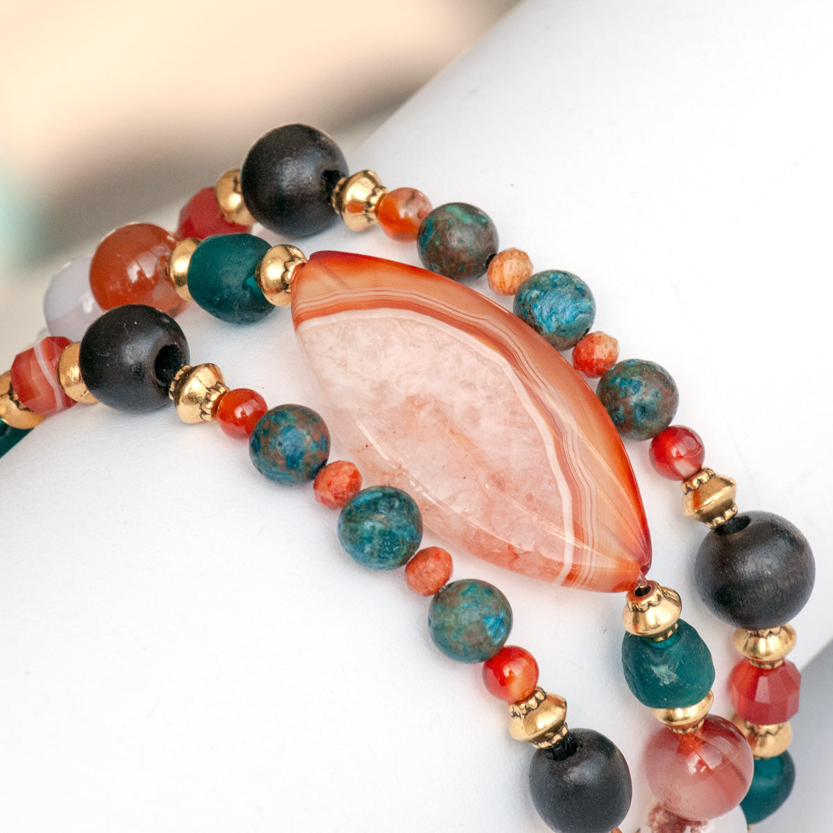 Handmade Voyage to Nairobi bracelet set featuring marquis-shaped Carnelian, red Sardonyx, dark teal recycled glass beads, and antique gold-plated spacers, inspired by African heritage.