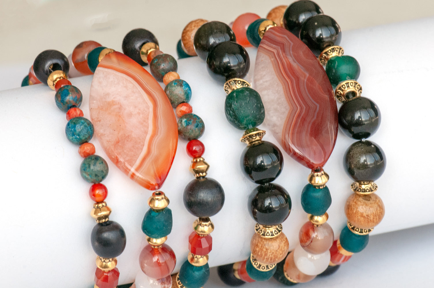 Handmade Voyage to Nairobi bracelet set featuring marquis-shaped Carnelian, red Sardonyx, dark teal recycled glass beads, and antique gold-plated spacers, inspired by African heritage.