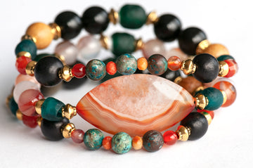 Handmade Voyage to Nairobi bracelet set featuring marquis-shaped Carnelian, red Sardonyx, dark teal recycled glass beads, and antique gold-plated spacers, inspired by African heritage.