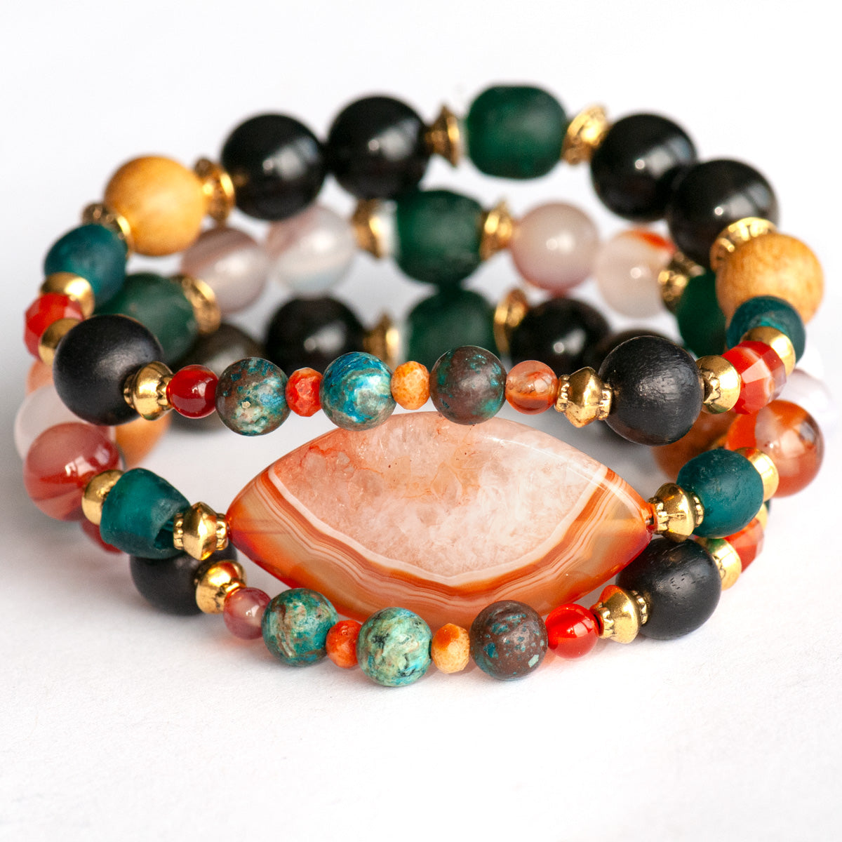 Handmade Voyage to Nairobi bracelet set featuring marquis-shaped Carnelian, red Sardonyx, dark teal recycled glass beads, and antique gold-plated spacers, inspired by African heritage.