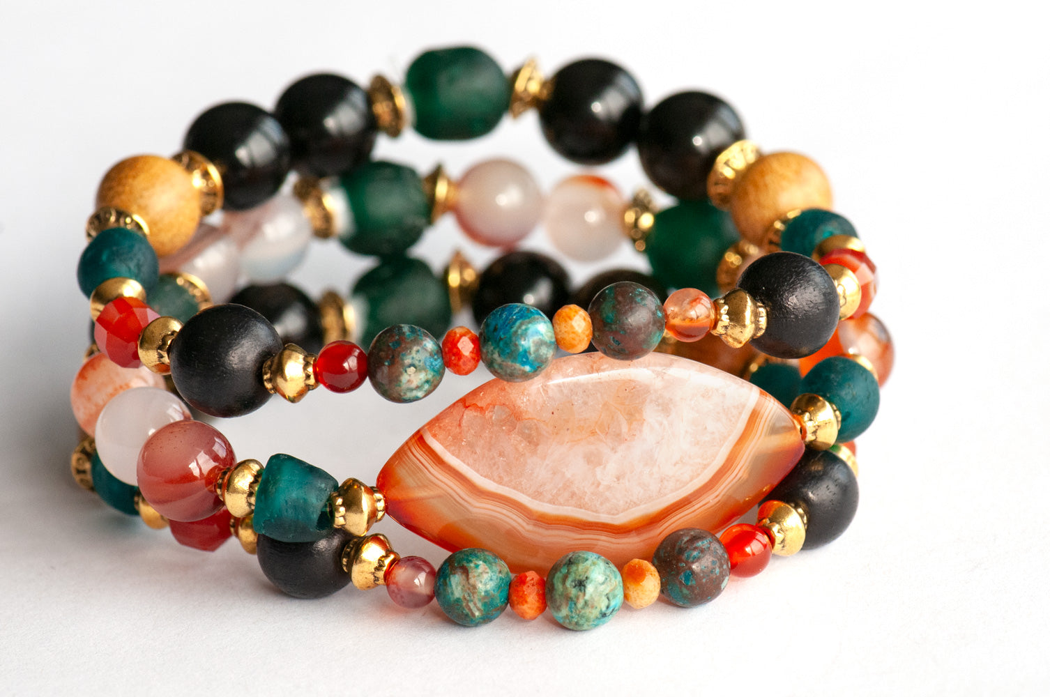 Handmade Voyage to Nairobi bracelet set featuring marquis-shaped Carnelian, red Sardonyx, dark teal recycled glass beads, and antique gold-plated spacers, inspired by African heritage.