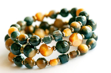 Tiger's Insight bracelet set featuring dark navy blue and golden yellow Tiger's Eye stones with chatoyant effects, accented by pyrite-plated hematite beads and antique gold spacers