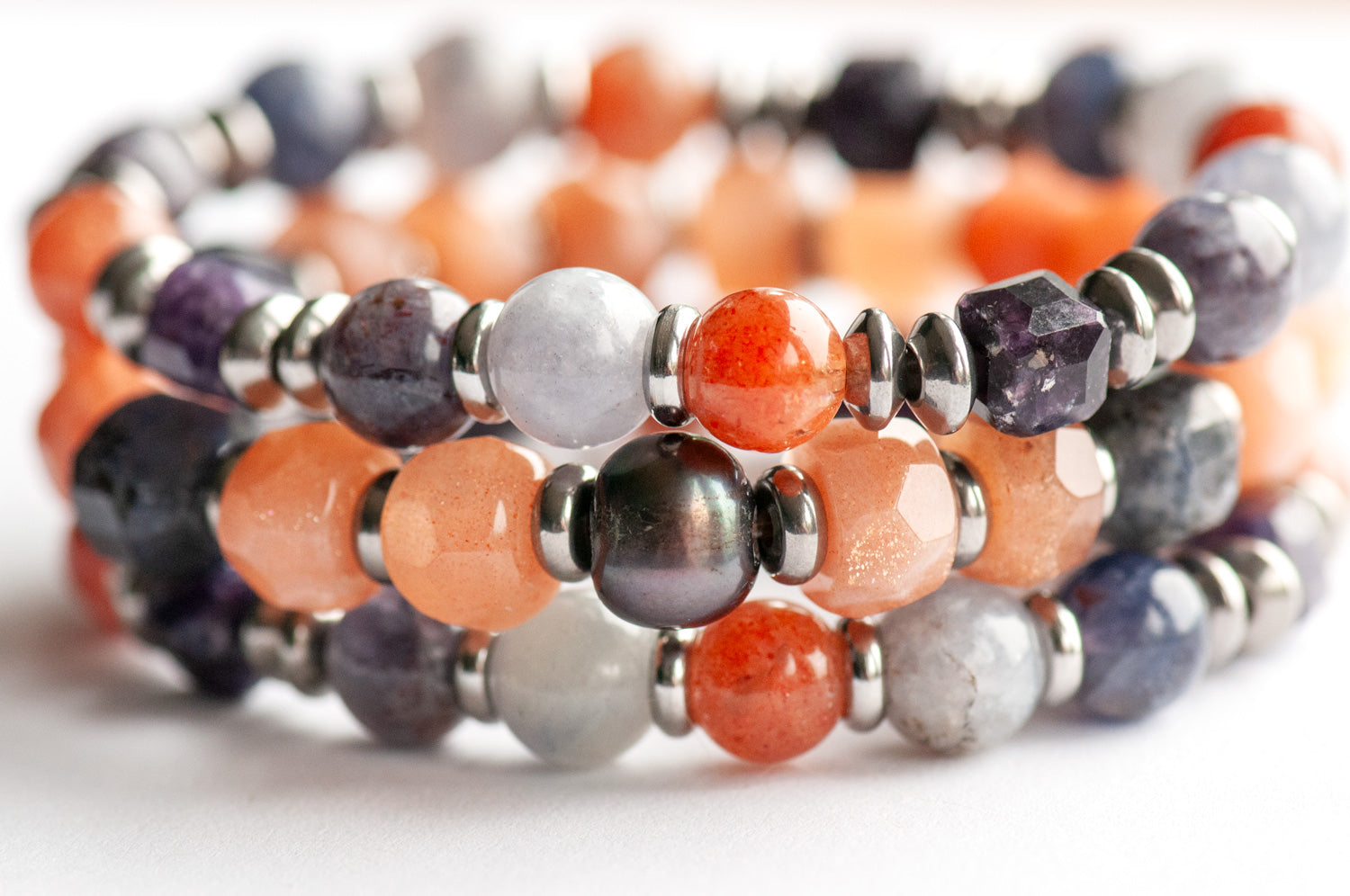 Mystical Lynx bracelet set featuring iridescent purple freshwater pearl, hand-faceted Sunstone, deep purple Iolite energy prisms, golden Sunstone, light blue Iolite, deep purple Lepidolite, and stainless steel accents