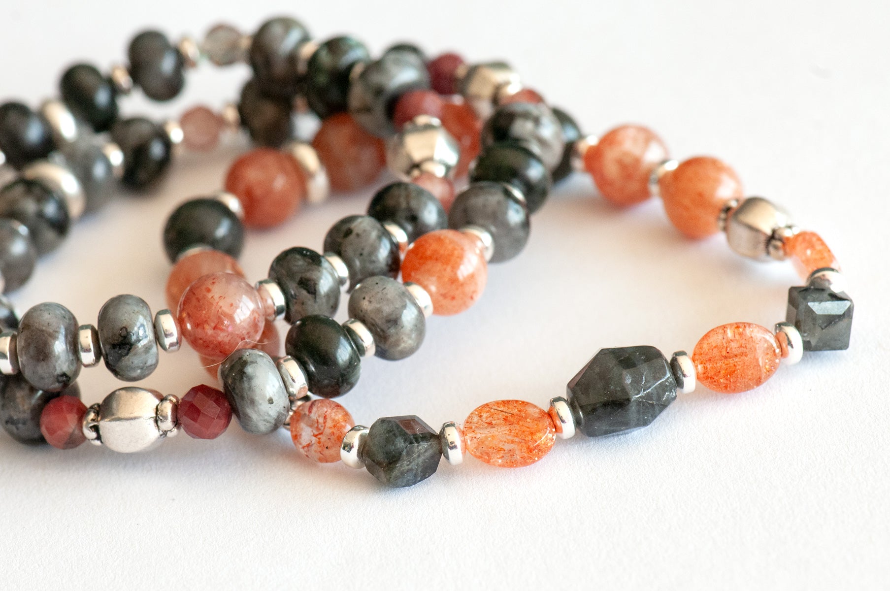 Fierce Balance bracelet set featuring hand-faceted Black Labradorite nugget, Sunstone ovals, Red Lazasine, Larvikite rondelles, and white silver Hematite spacers, part of the Fierce Friendship Collection.