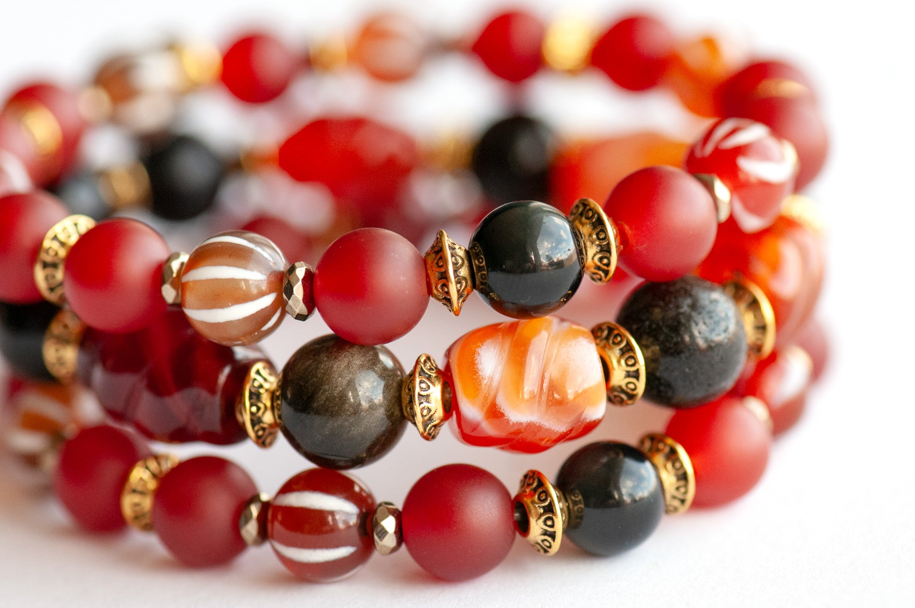 Close-up of carved Carnelian and Golden Obsidian beads in the Fierce Empowerment focal bracelet.