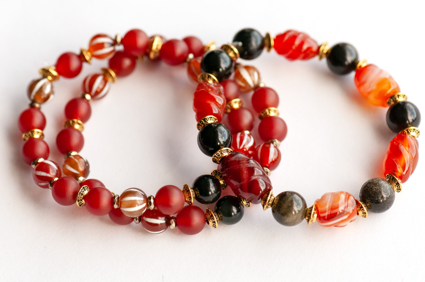 Supporting bracelets with Dzi Agate, matte Carnelian, and pyrite-plated Hematite in the Fierce Empowerment set