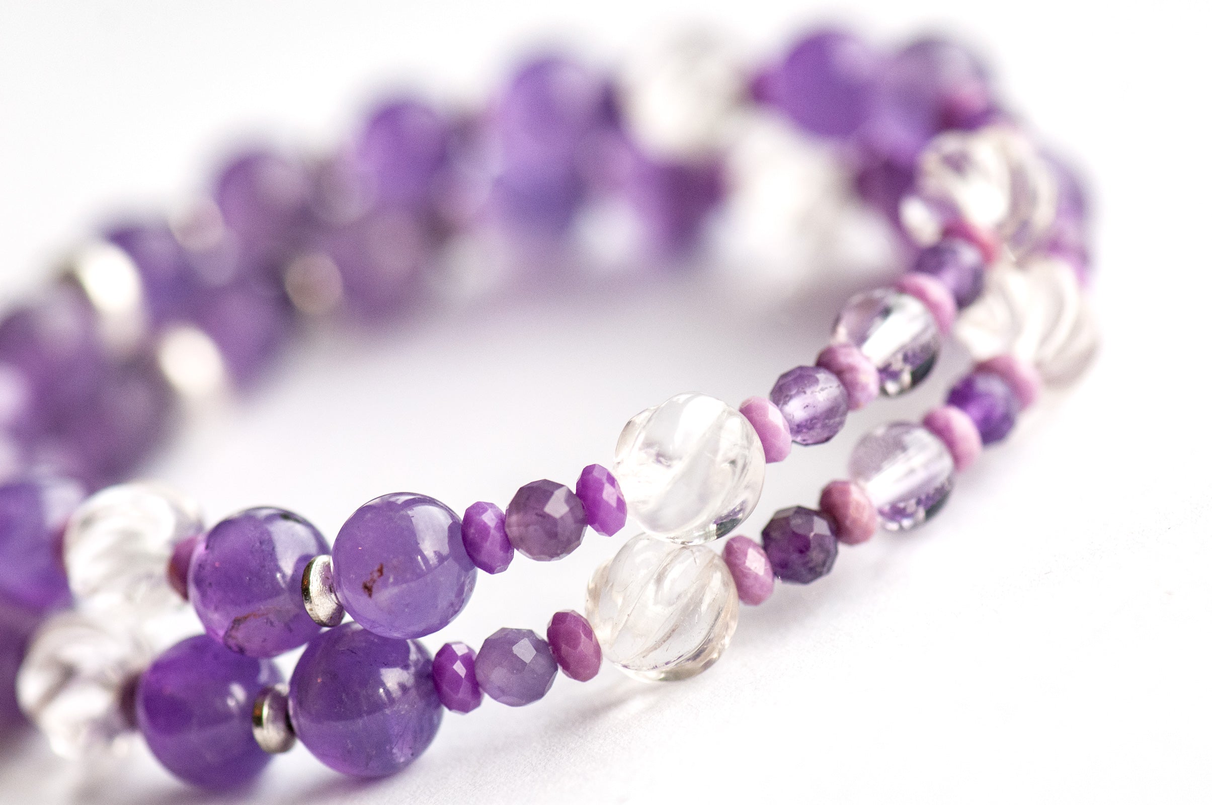 Supporting bracelets with Amethyst rounds, Phosphosiderite rondelles, and silver-plated spacers in the Fierce Patience set.