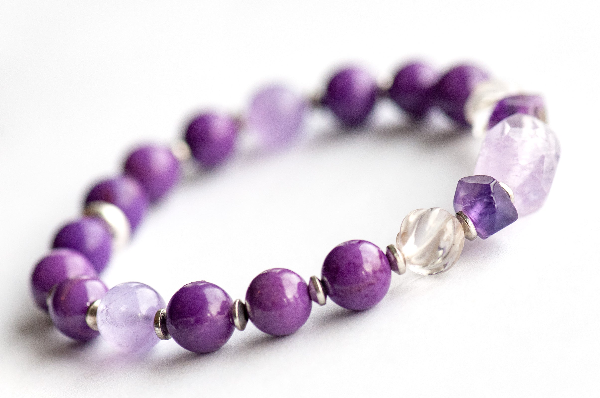 Close-up of faceted Amethyst chips and carved crystal Quartz beads in the Fierce Patience focal bracelet.