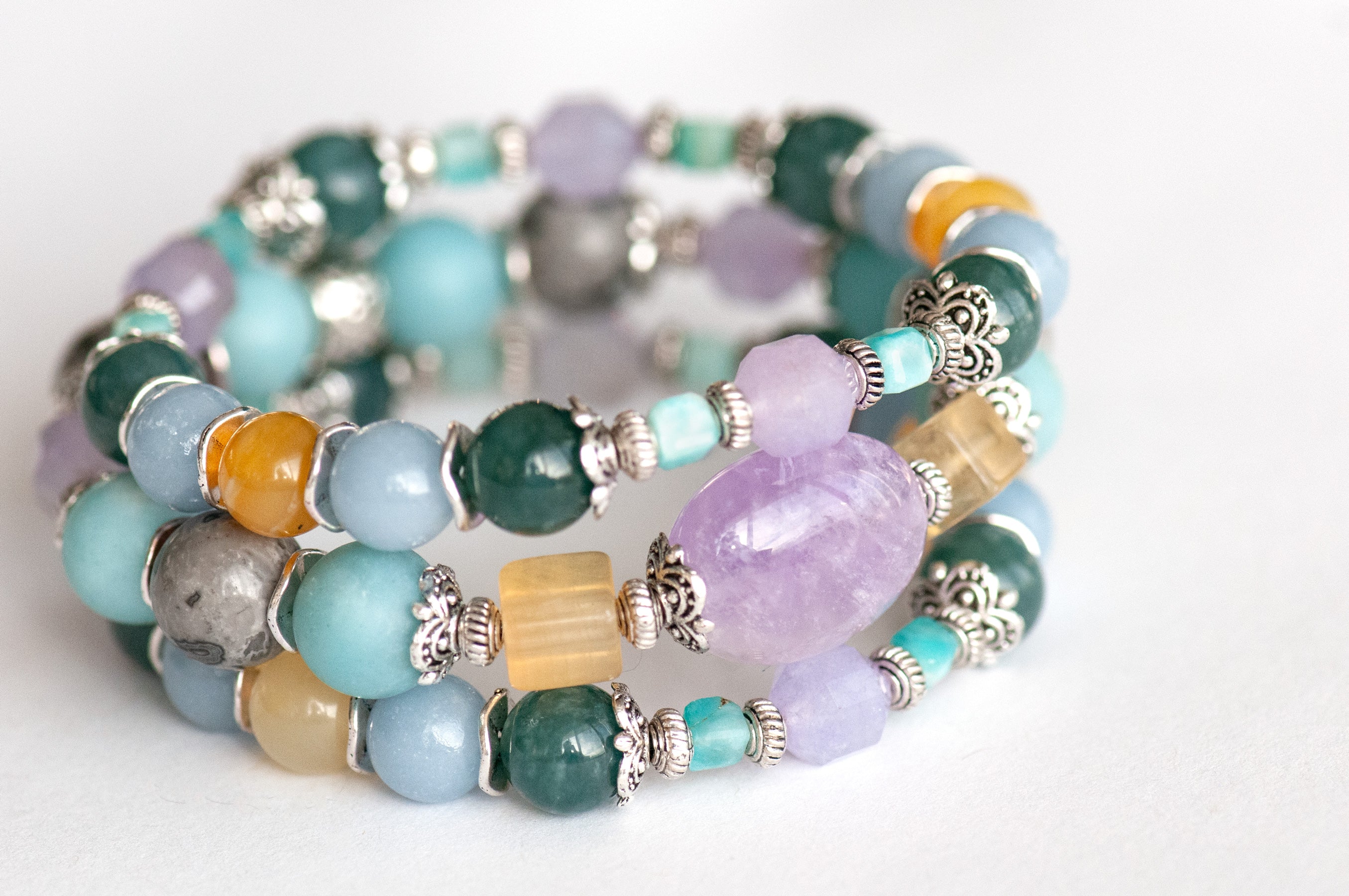 Close-up of the focal bracelet with a 15mm lavender amethyst nugget framed by bright yellow fluorite cubes, matte amazonite, and silver crazy lace agate rounds.
