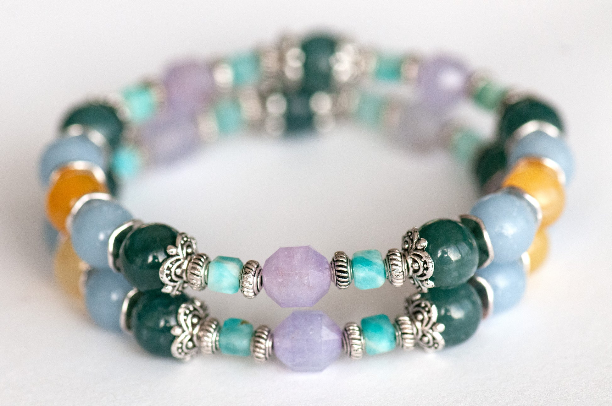 Two supporting bracelets showcasing rare Guatemalan blue-green jade, soft blue angelite, yellow opal rounds, and brilliant blue Brazilian amazonite cubes.
