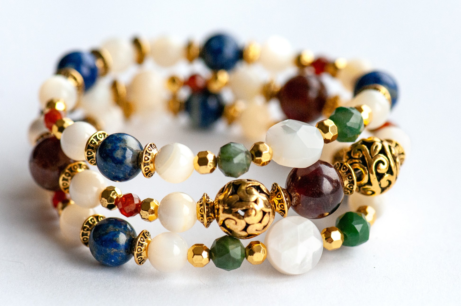 Baroque Lynx gemstone bracelet set stacked together showcasing rich jewel tones, creamy pearls, and golden accents in a Baroque-inspired design