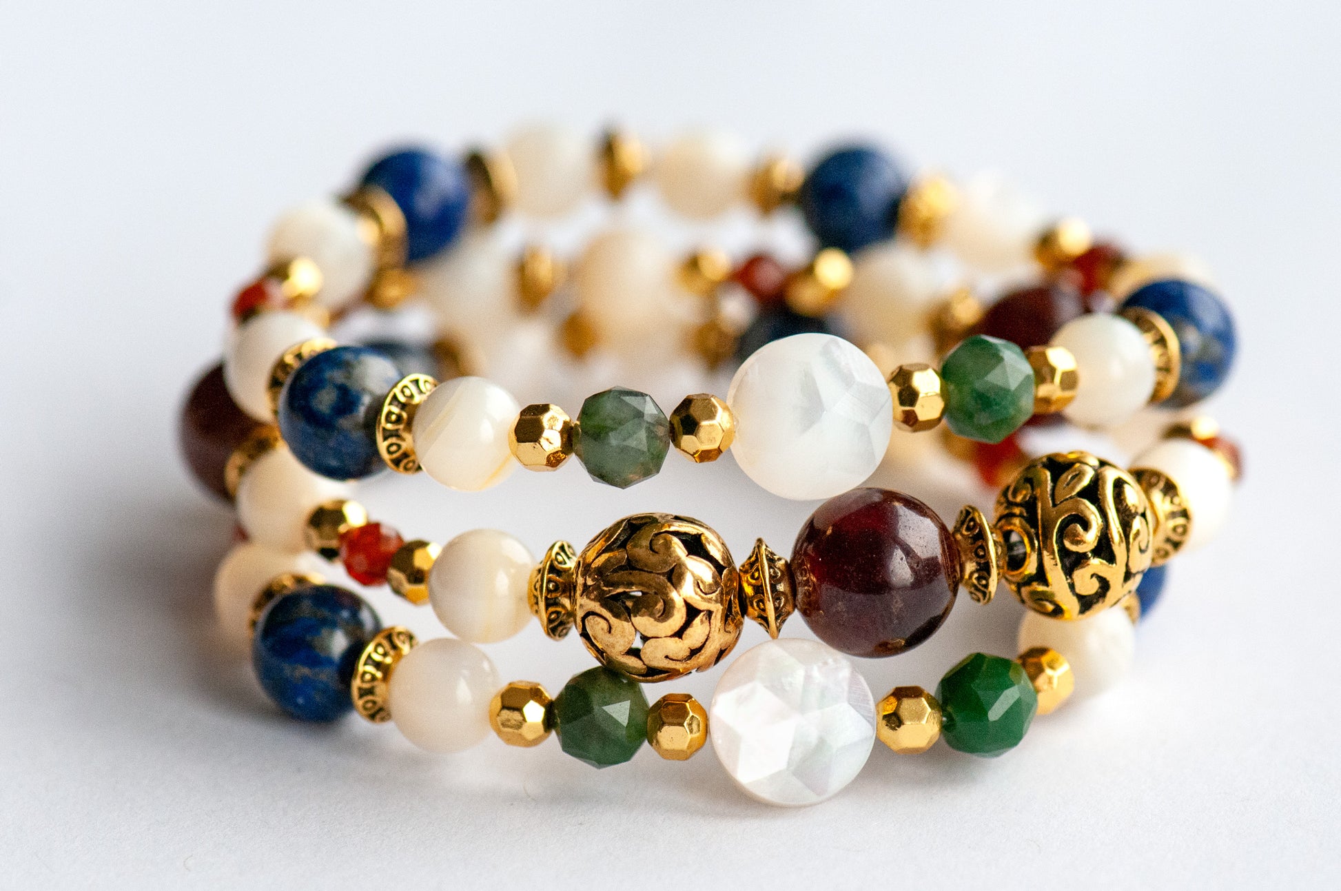 Baroque Lynx gemstone bracelet set stacked together showcasing rich jewel tones, creamy pearls, and golden accents in a Baroque-inspired design
