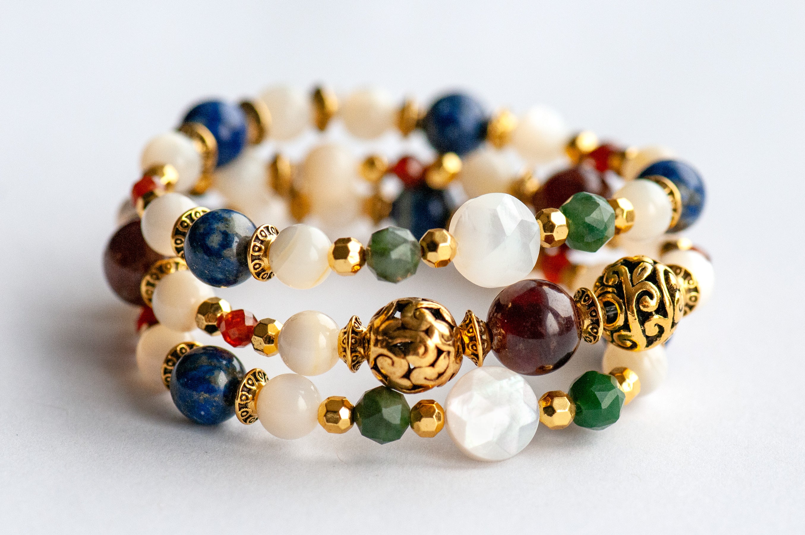 Baroque Lynx gemstone bracelet set stacked together showcasing rich jewel tones, creamy pearls, and golden accents in a Baroque-inspired design