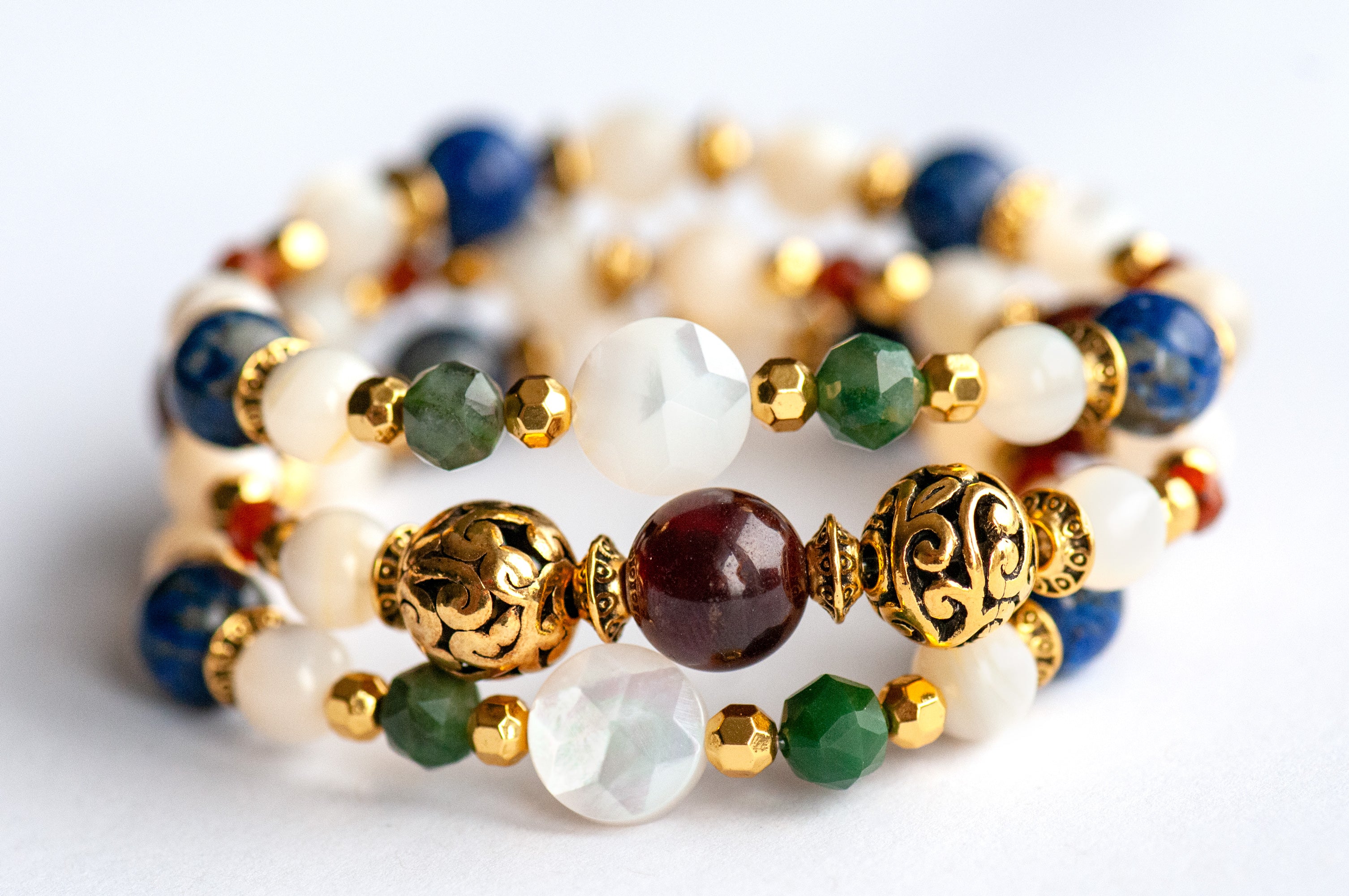 Baroque Lynx gemstone bracelet set stacked together showcasing rich jewel tones, creamy pearls, and golden accents in a Baroque-inspired design