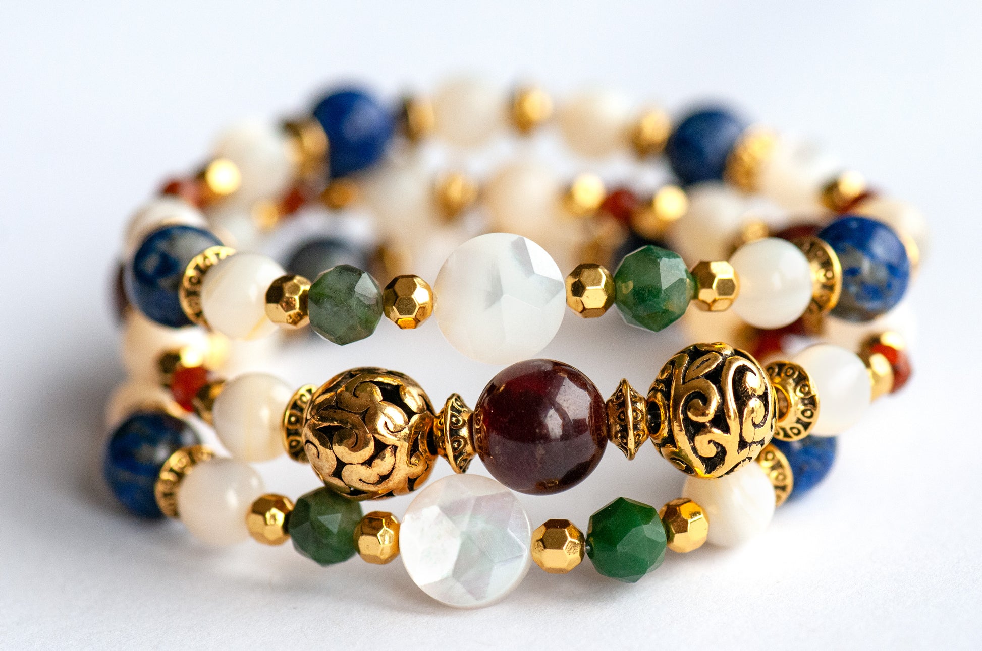 Baroque Lynx gemstone bracelet set stacked together showcasing rich jewel tones, creamy pearls, and golden accents in a Baroque-inspired design