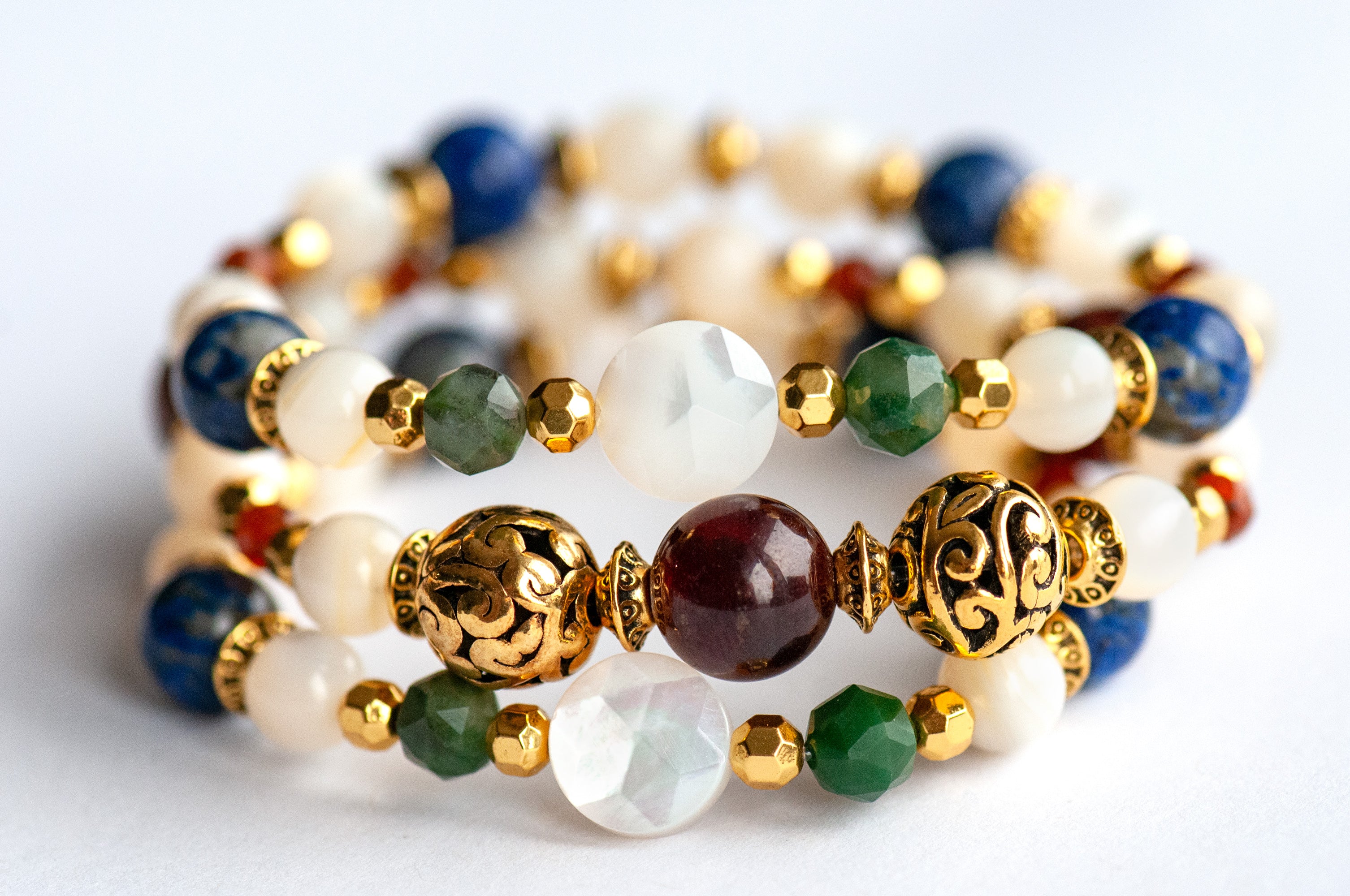 Baroque Lynx gemstone bracelet set stacked together showcasing rich jewel tones, creamy pearls, and golden accents in a Baroque-inspired design