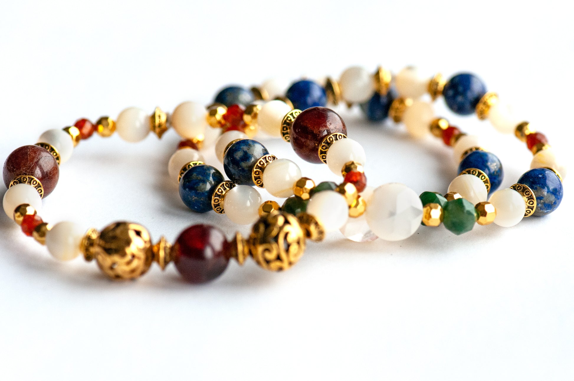 Baroque Lynx gemstone bracelet set stacked together showcasing rich jewel tones, creamy pearls, and golden accents in a Baroque-inspired design