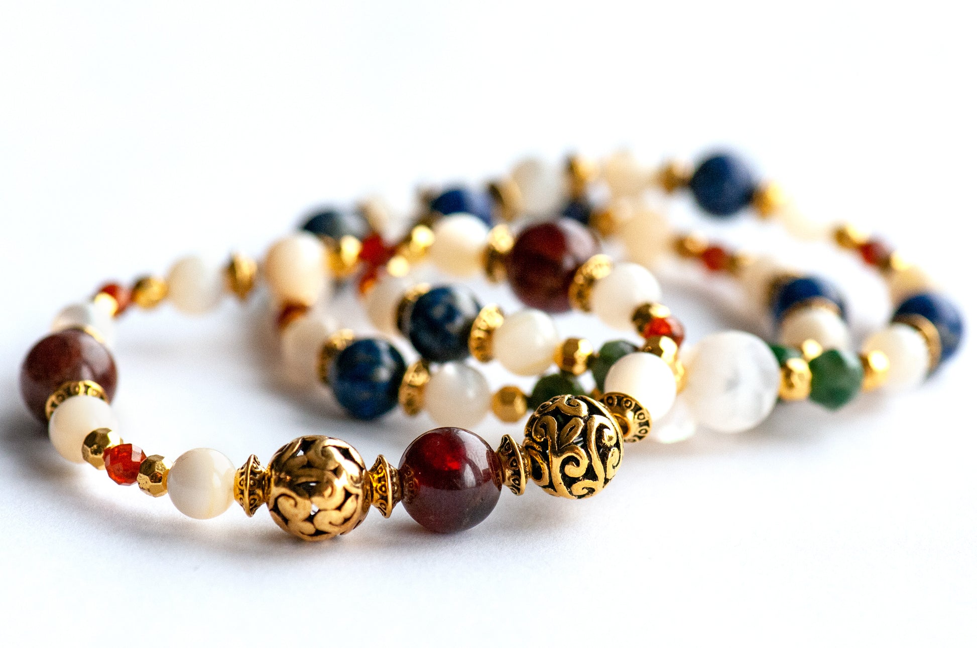 Baroque Lynx gemstone bracelet set stacked together showcasing rich jewel tones, creamy pearls, and golden accents in a Baroque-inspired design