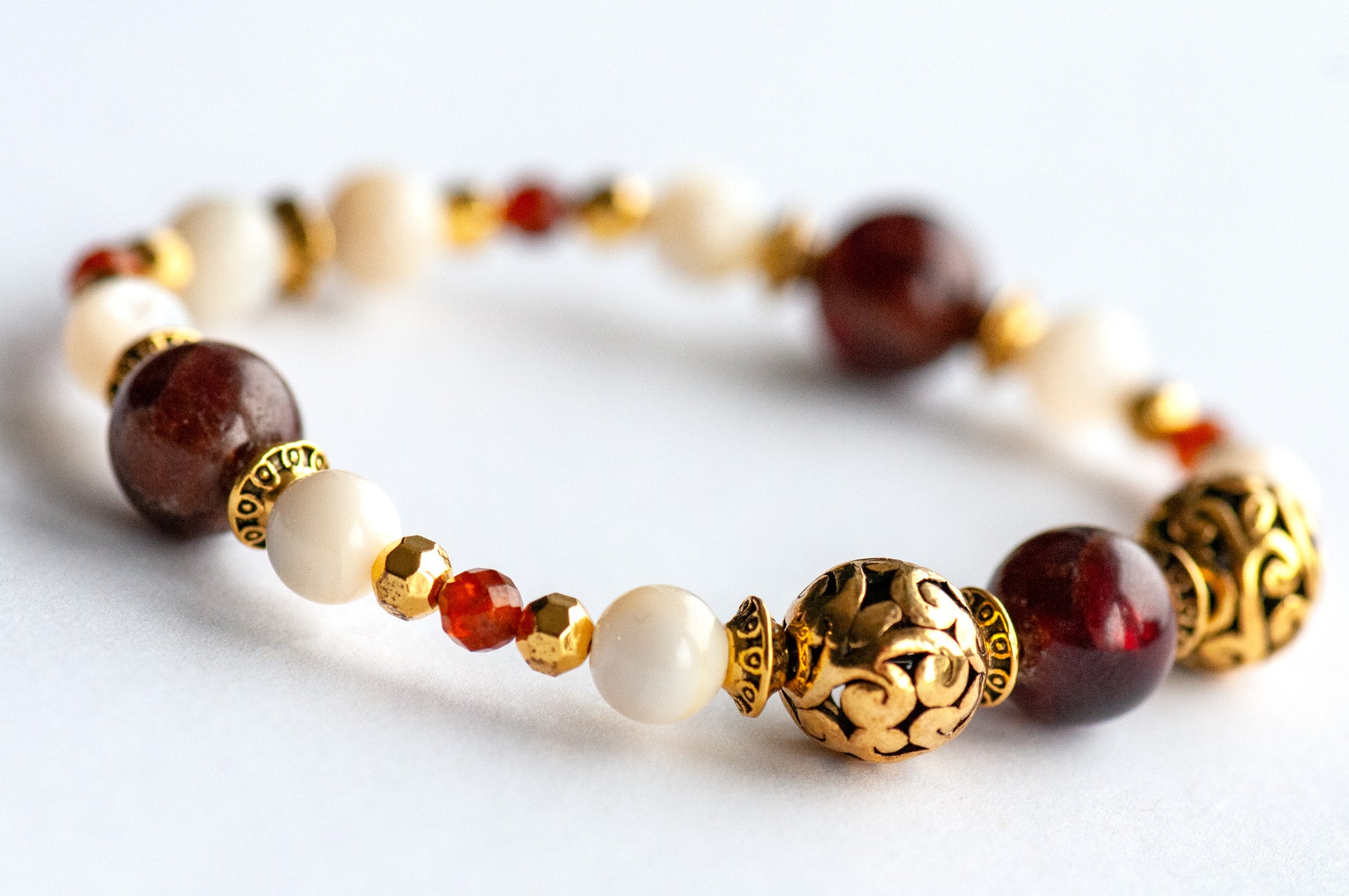 Baroque Lynx focal bracelet featuring Hessonite Garnet beads with creamy shell beads and gold Hematite spacers, inspired by Baroque elegance