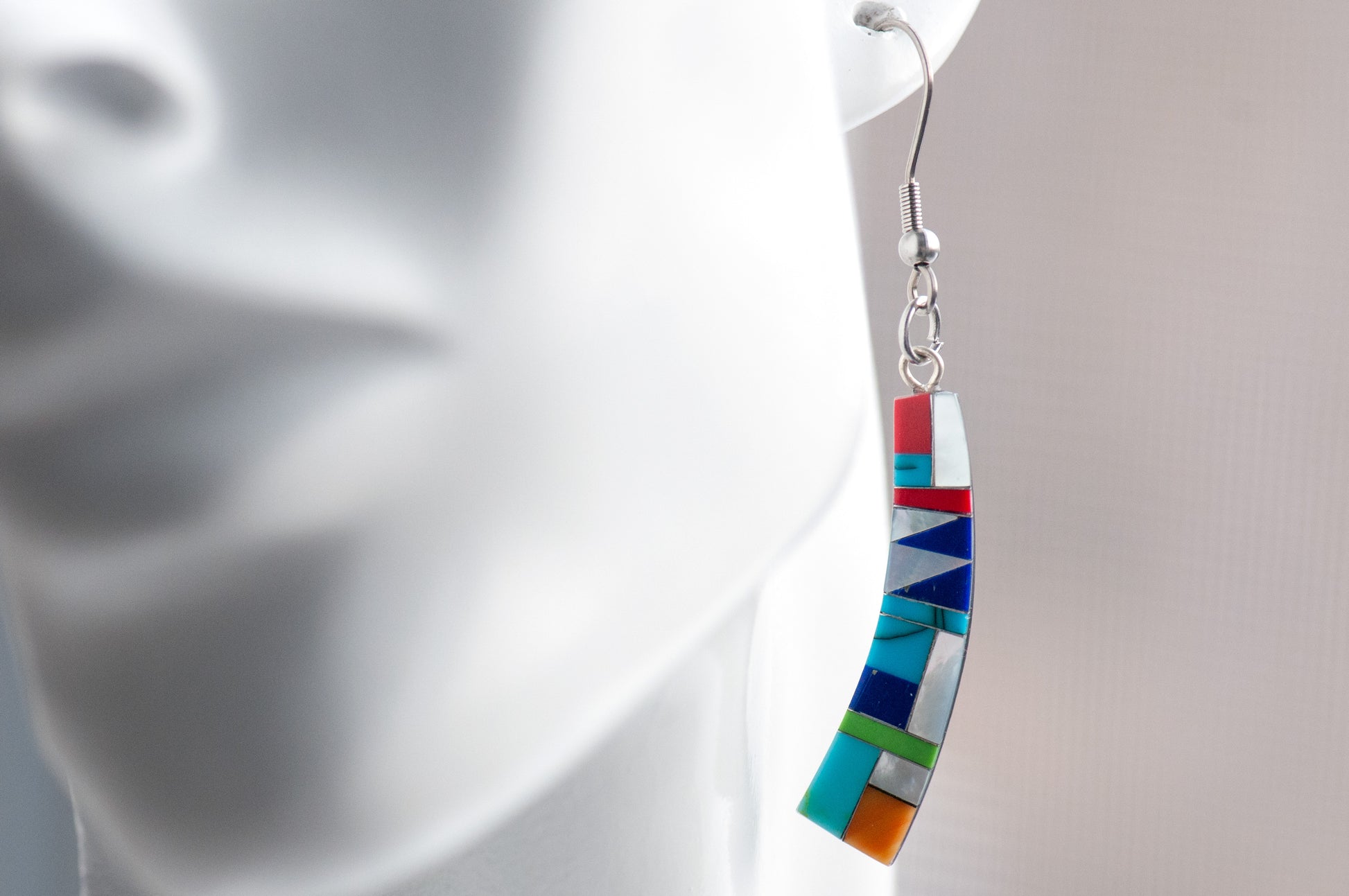 Turquoise Mosaic Curve Earrings featuring turquoise, coral, Mother of Pearl, and green and navy stones in a black resin curved rectangular design