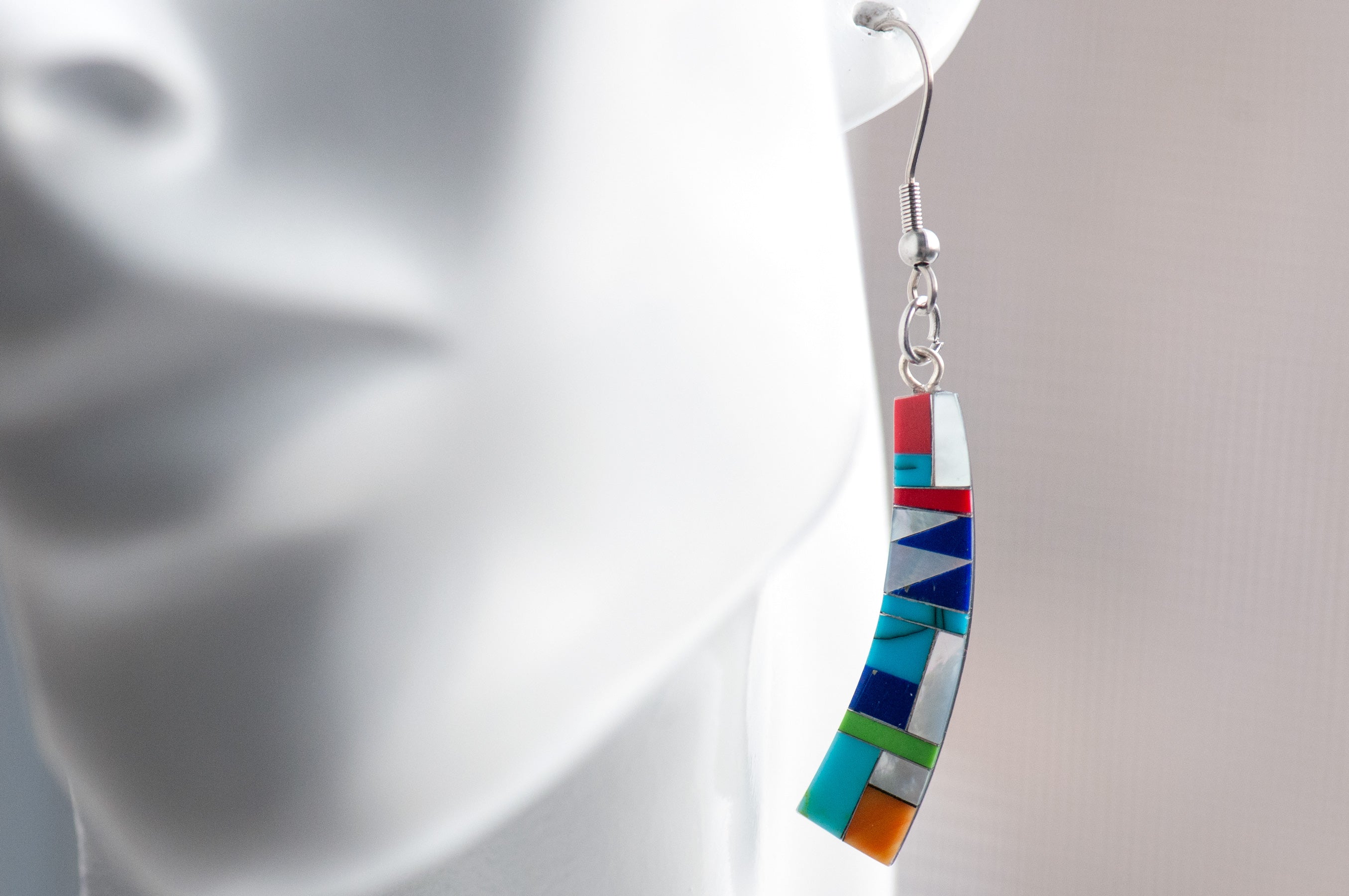 Turquoise Mosaic Curve Earrings featuring turquoise, coral, Mother of Pearl, and green and navy stones in a black resin curved rectangular design