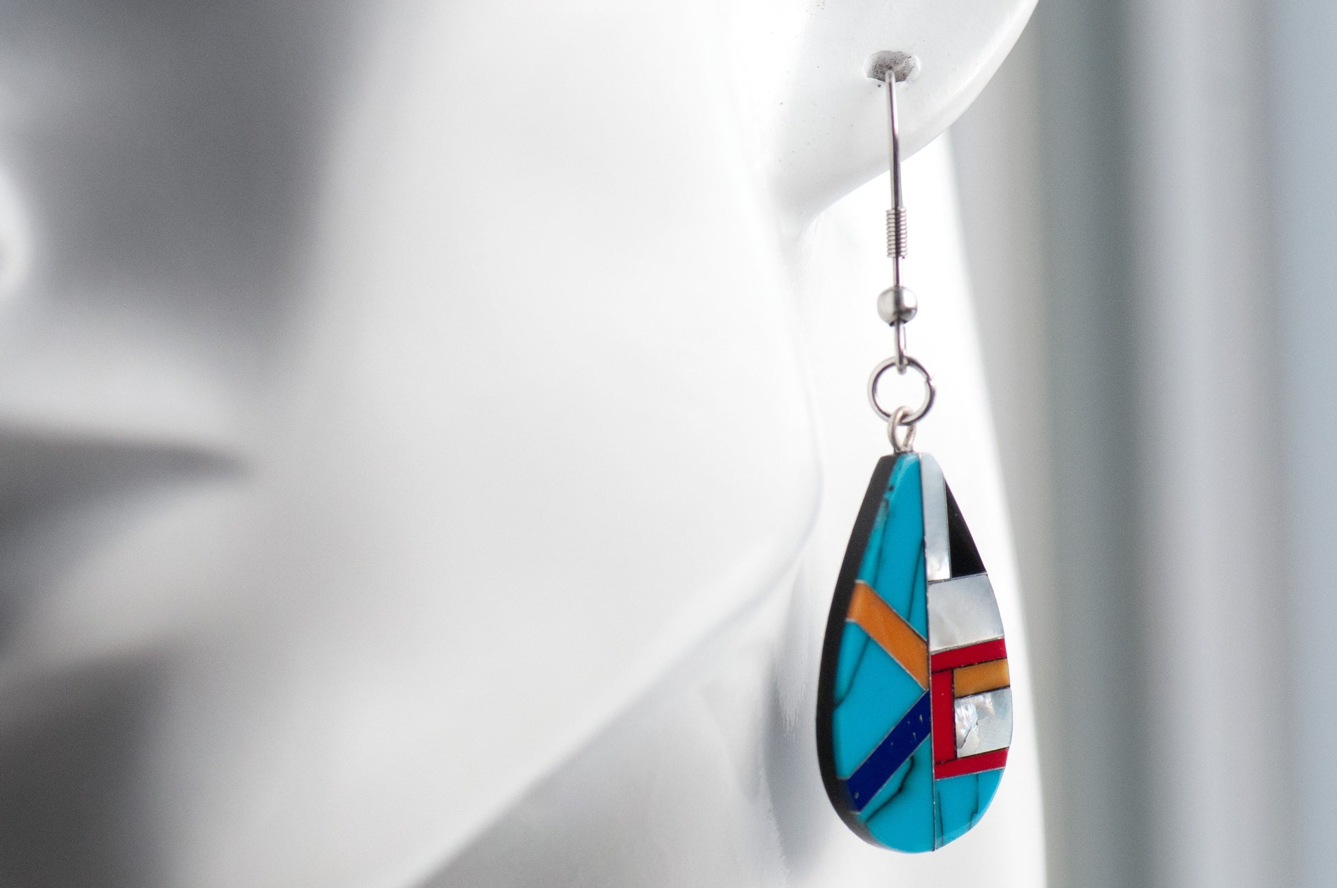 Turquoise & Pearl Teardrop Earrings featuring authentic turquoise, red and orange coral, and creamy Mother of Pearl in a black resin teardrop design.