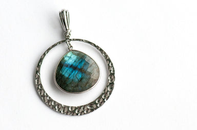 Moonlit Lynx Labradorite pendant featuring a pear-shaped stone in a silver bezel with a hammered silver ring and plated bail.