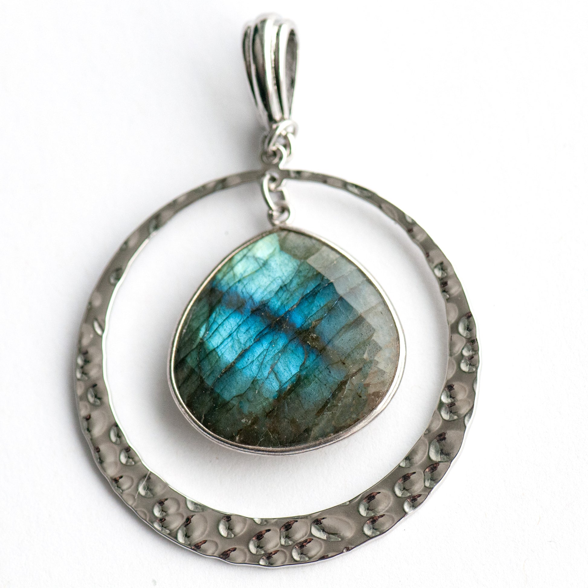 Moonlit Lynx Labradorite pendant featuring a pear-shaped stone in a silver bezel with a hammered silver ring and plated bail.