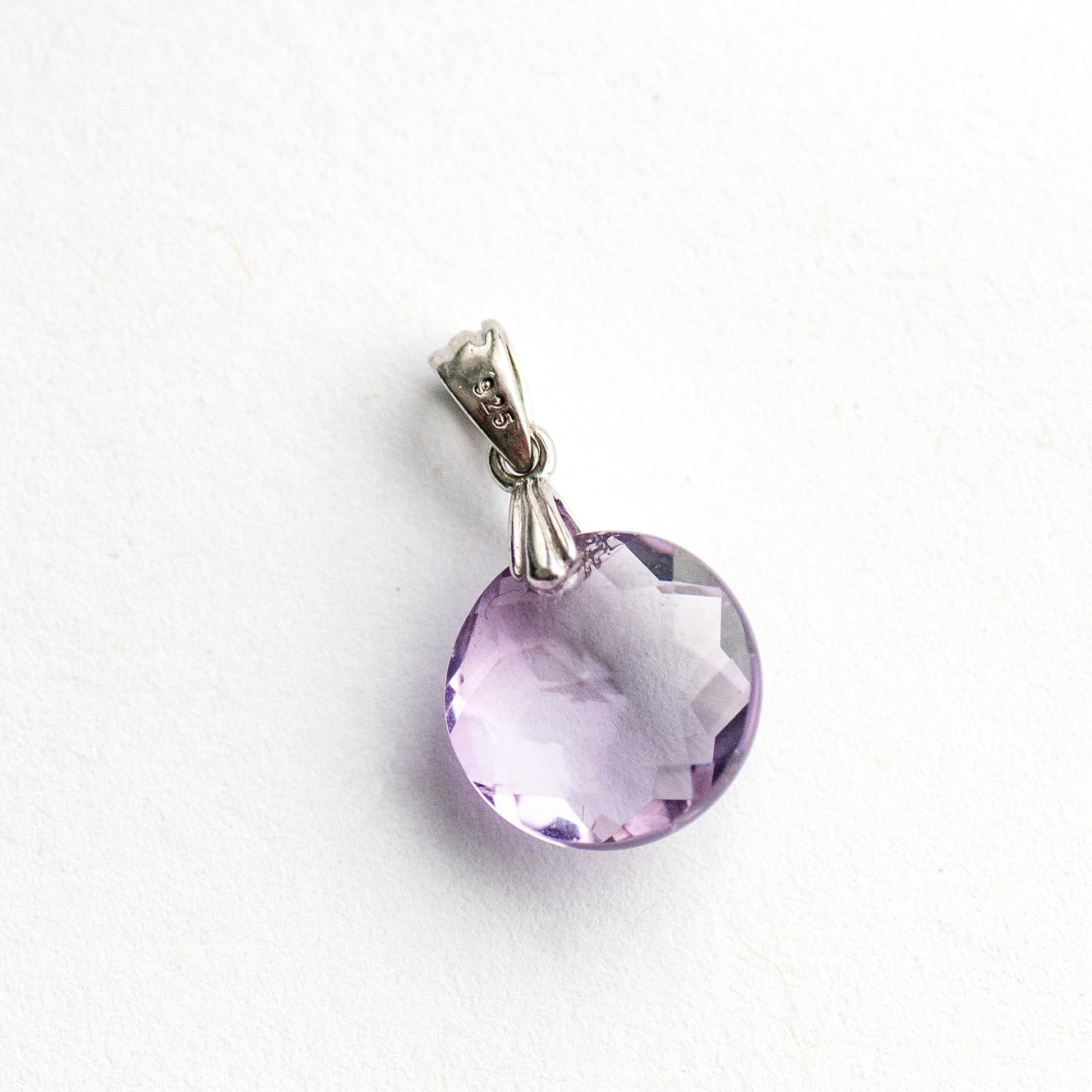 Amethyst Star Lynx pendant featuring a 12mm Amethyst coin with a starburst facet pattern and sterling silver bail.