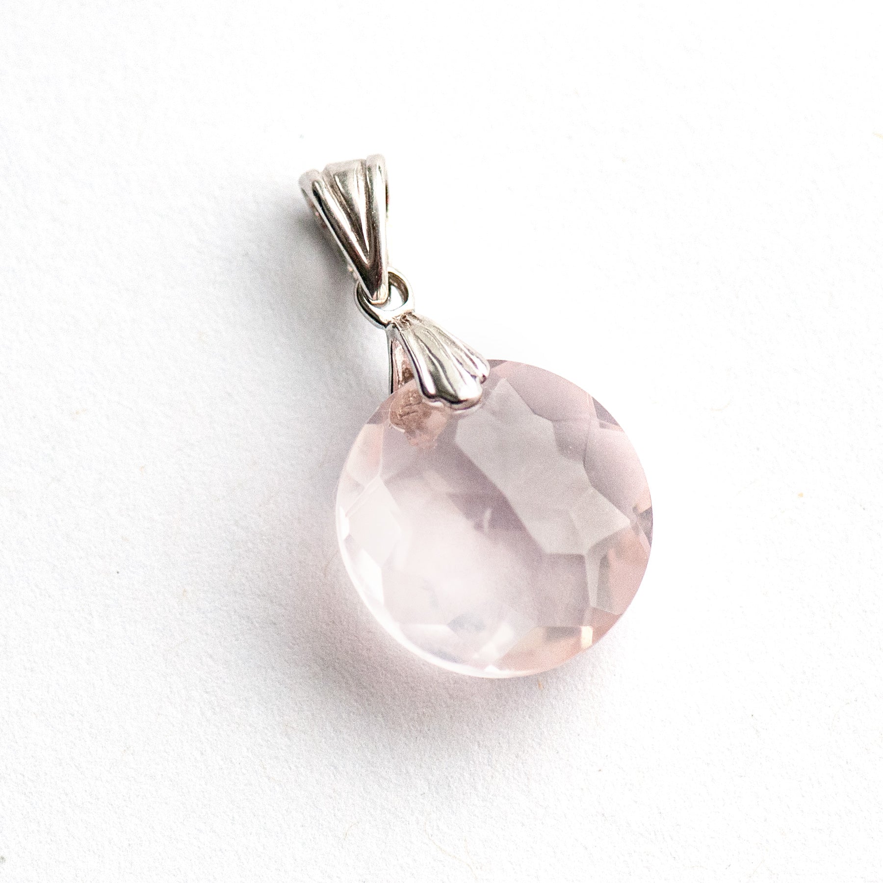 Rose Quartz Glow Lynx pendant featuring a 14mm Rose Quartz coin with a starburst facet pattern and sterling silver bail.