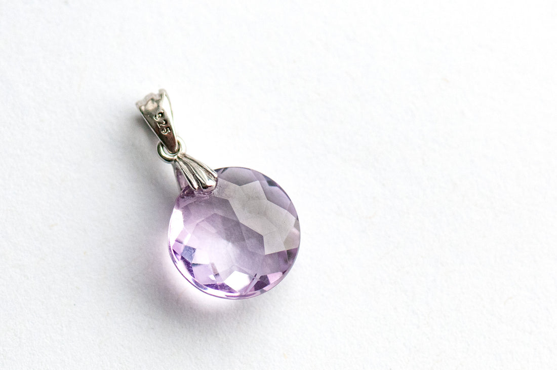 Amethyst Star Lynx pendant featuring a 12mm Amethyst coin with a starburst facet pattern and sterling silver bail.