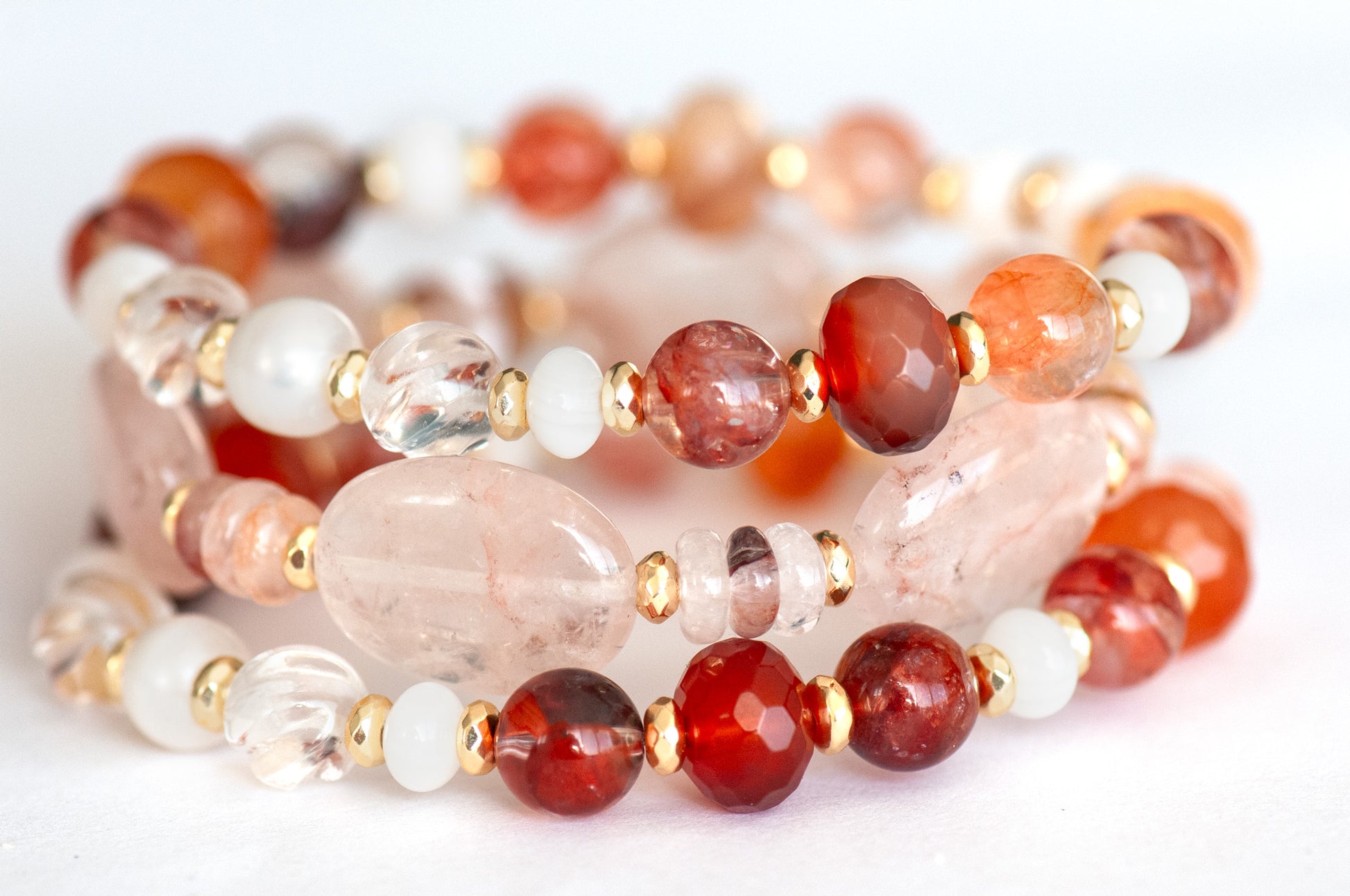 Stacked bracelet set showcasing Carnelian, Hematoid Quartz, and freshwater shell rondelles.