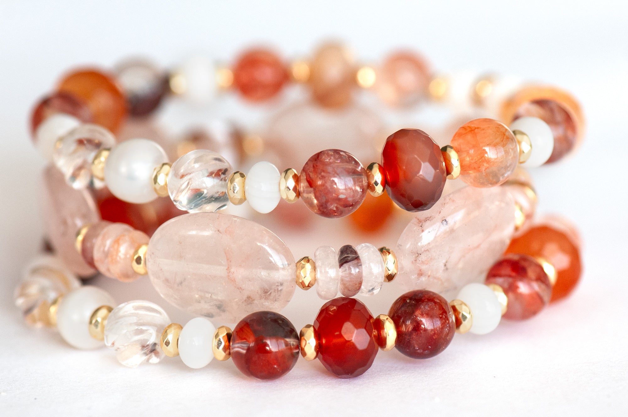 Stacked bracelet set showcasing Carnelian, Hematoid Quartz, and freshwater shell rondelles.