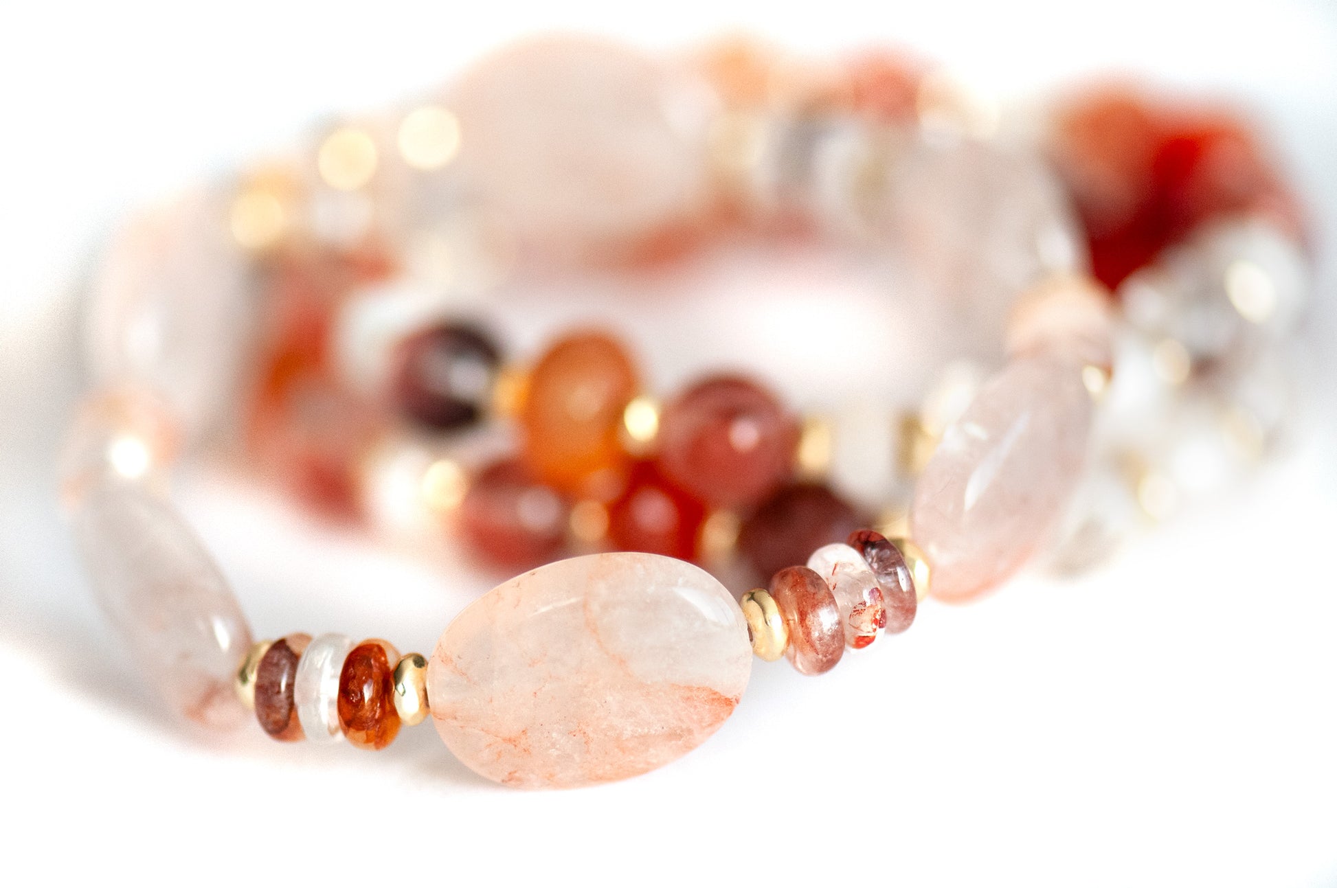 Close-up of Hematoid Quartz ovals with peach-pink inclusions and gold-plated Hematite spacers.
