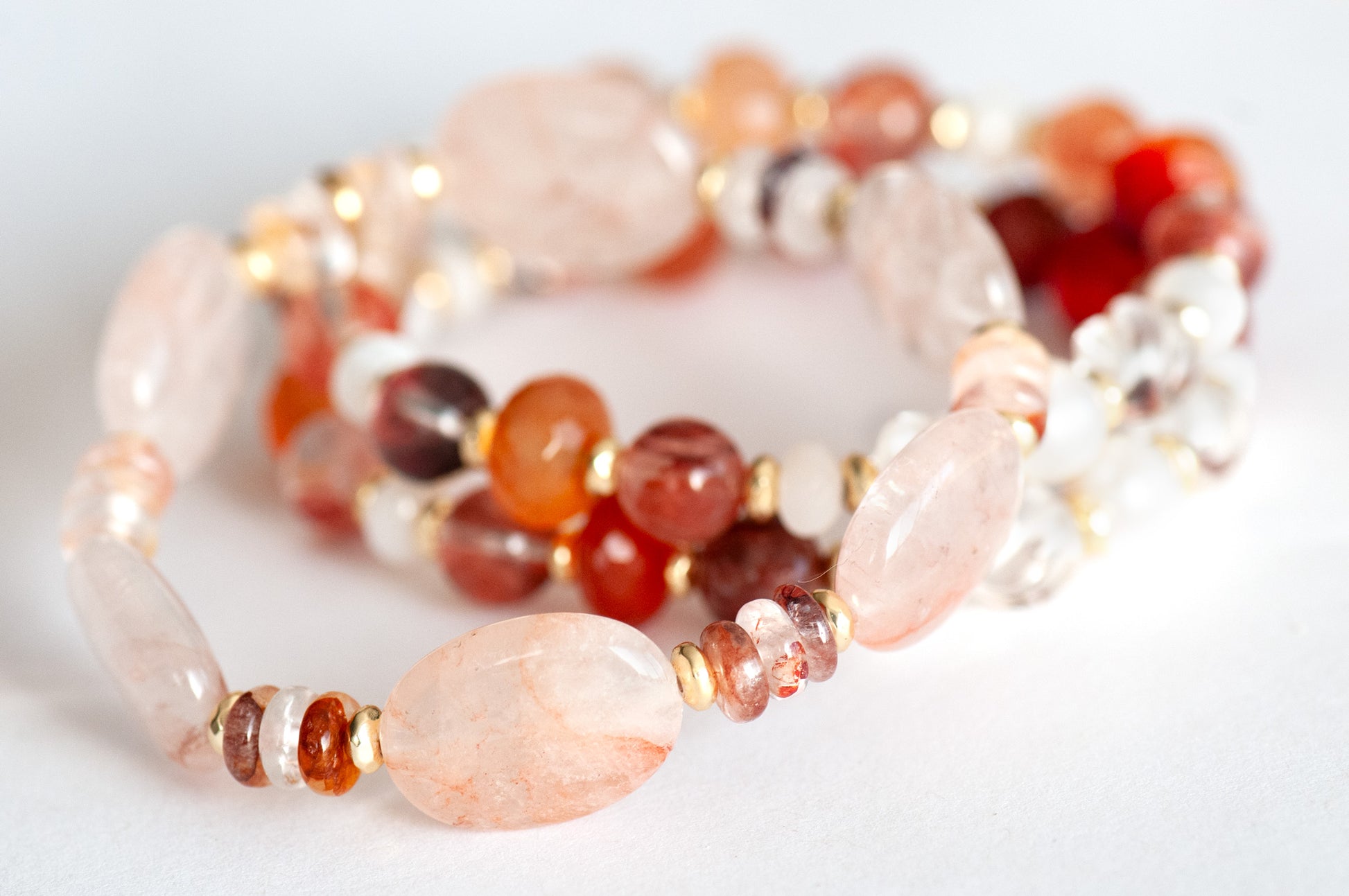 Close-up of Hematoid Quartz ovals with peach-pink inclusions and gold-plated Hematite spacers.