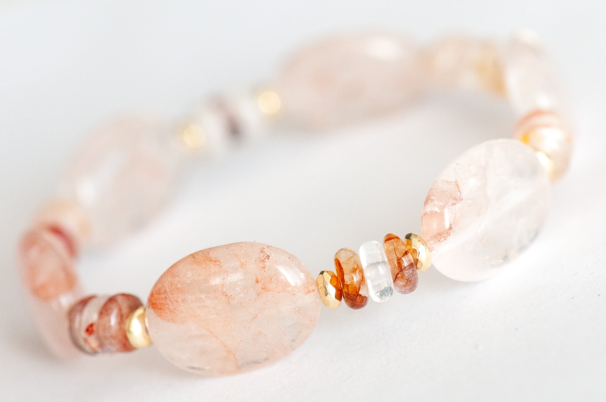 Close-up of Hematoid Quartz ovals with peach-pink inclusions and gold-plated Hematite spacers.
