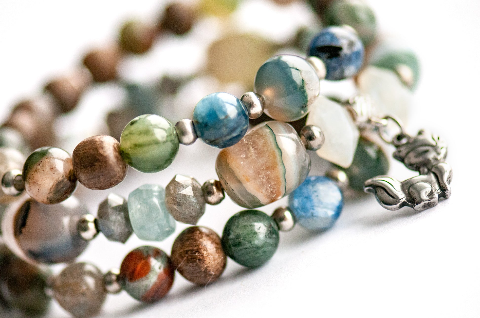 Close-up of Phantom Agate tube beads in shades of blue, red, and brown