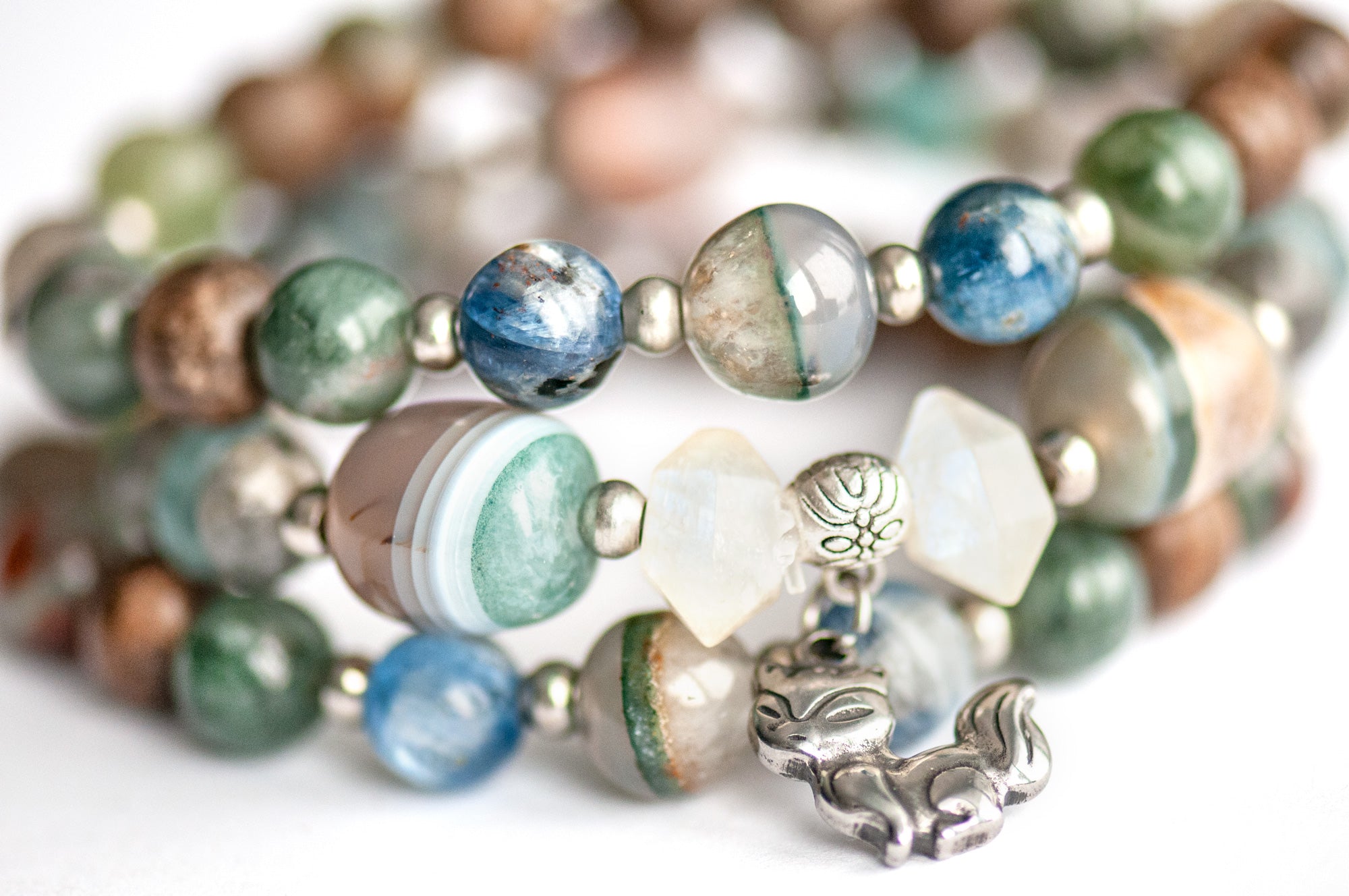 Close-up of Phantom Agate tube beads in shades of blue, red, and brown