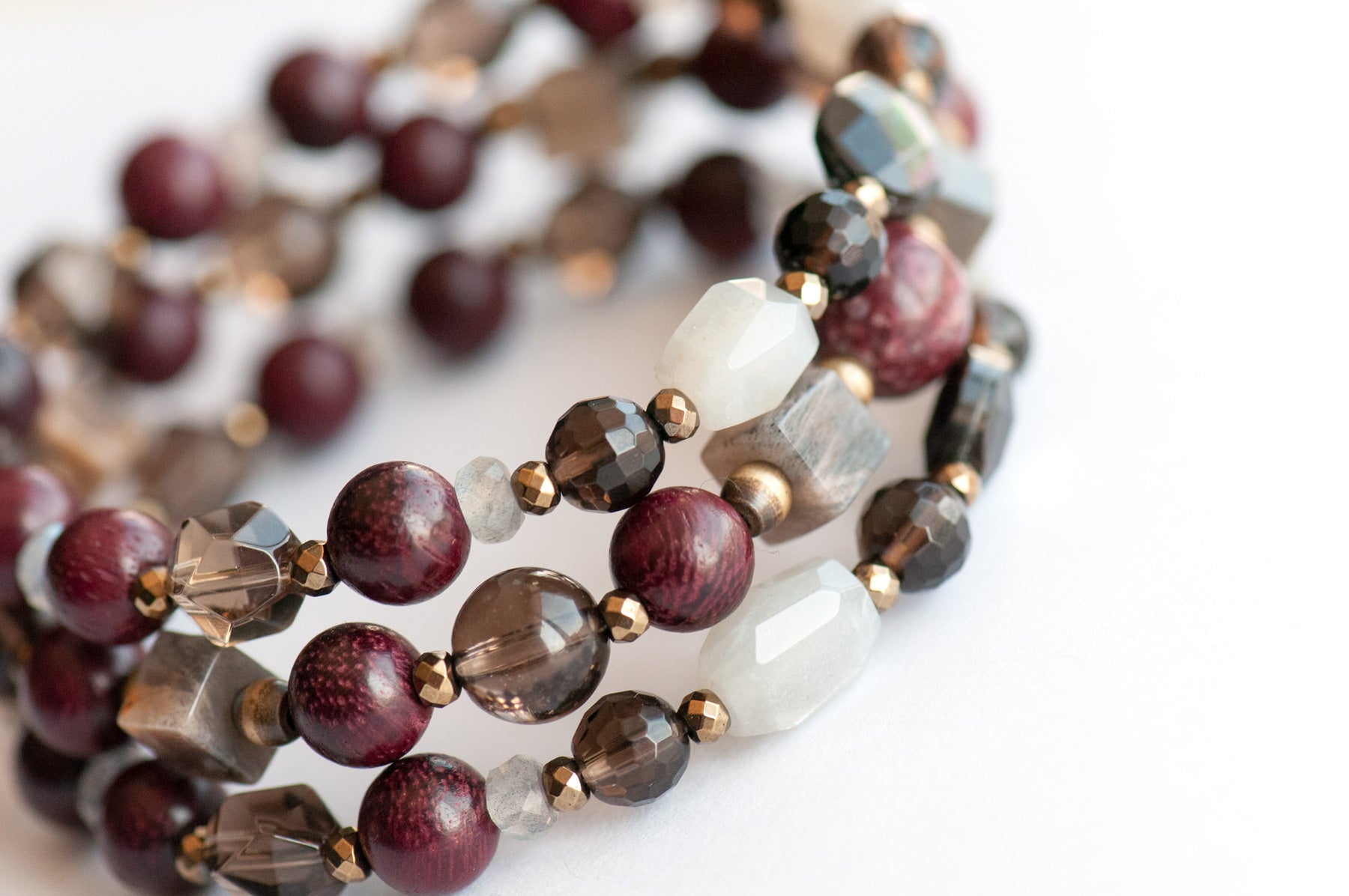 Handcrafted Morrigan gemstone bracelet set featuring rare Eudialyte, Grey Moonstone, Smoky Quartz, Labradorite, and Purpleheart Wood beads