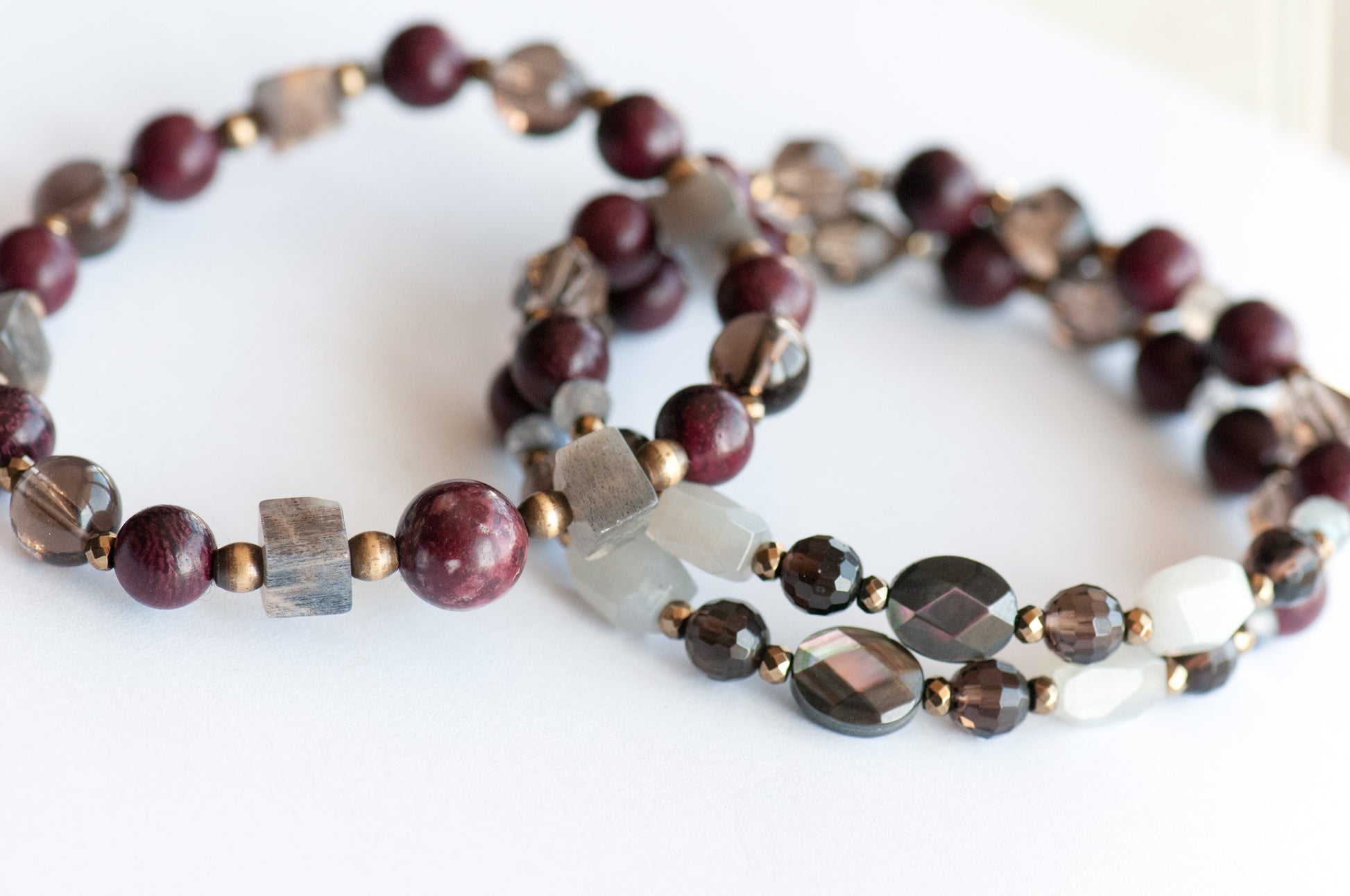Handcrafted Morrigan gemstone bracelet set featuring rare Eudialyte, Grey Moonstone, Smoky Quartz, Labradorite, and Purpleheart Wood beads