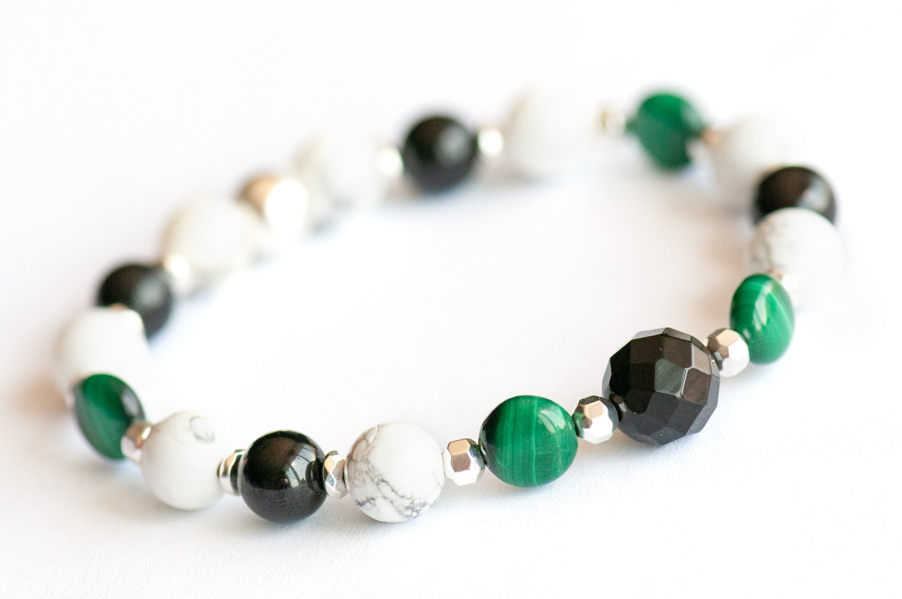Close-up of Art Deco Lynx focal bracelet with faceted Onyx and puffed Malachite coins